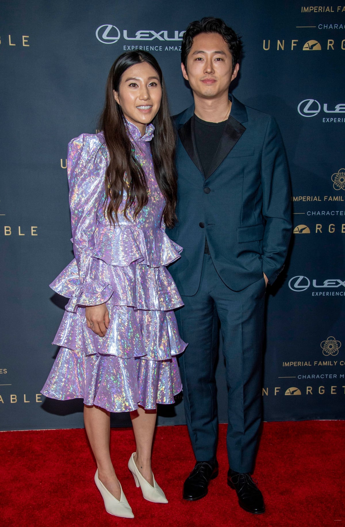 Steven Yeun looked dapper in a teal tailored suit and black dress shoes, while Joana Pak turned heads in a tiered iridescent ruffle dress paired with sculptural white heels
