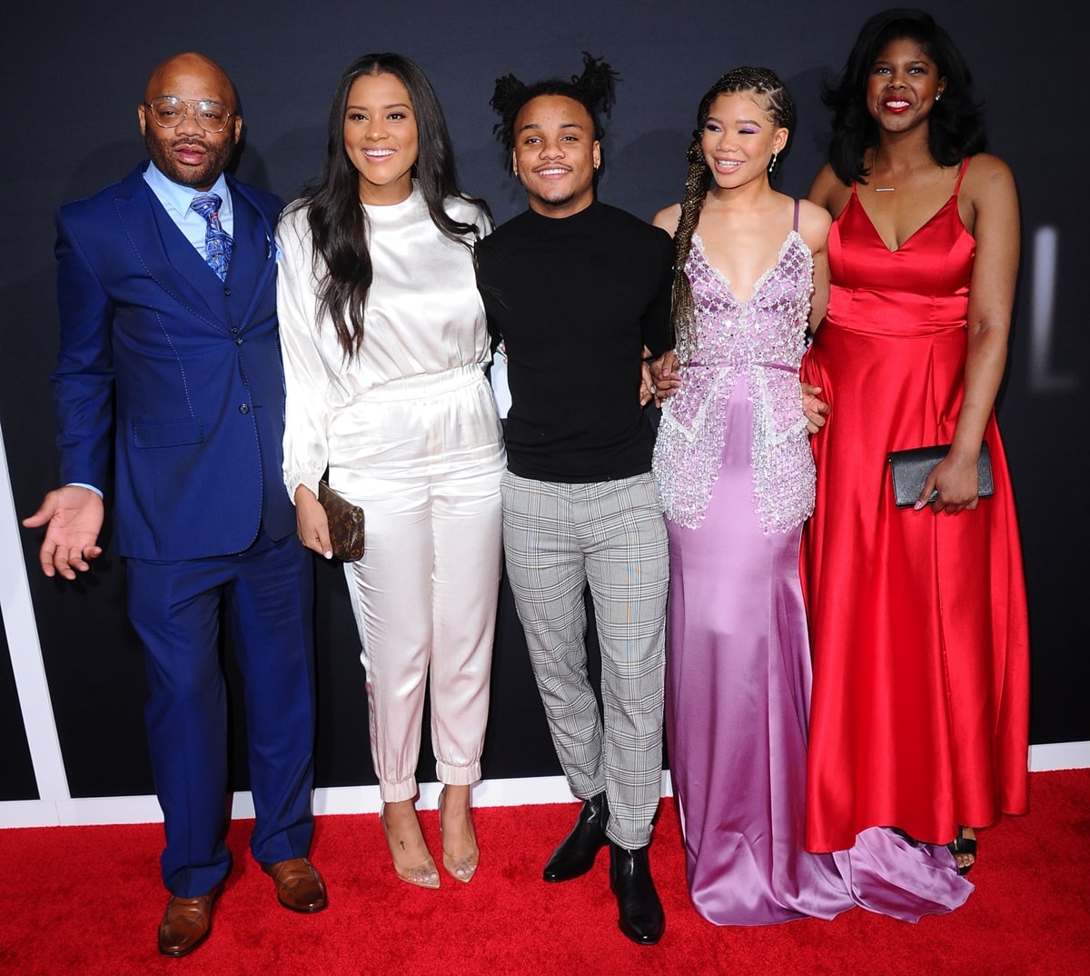 Storm Reid poses with her father, Rodney Reid, her brother Josh, and her sisters Iman and Paris at the Los Angeles premiere of “The Invisible Man,” stunning in a lilac Miu Miu satin gown adorned with crystal and pearl embellishments