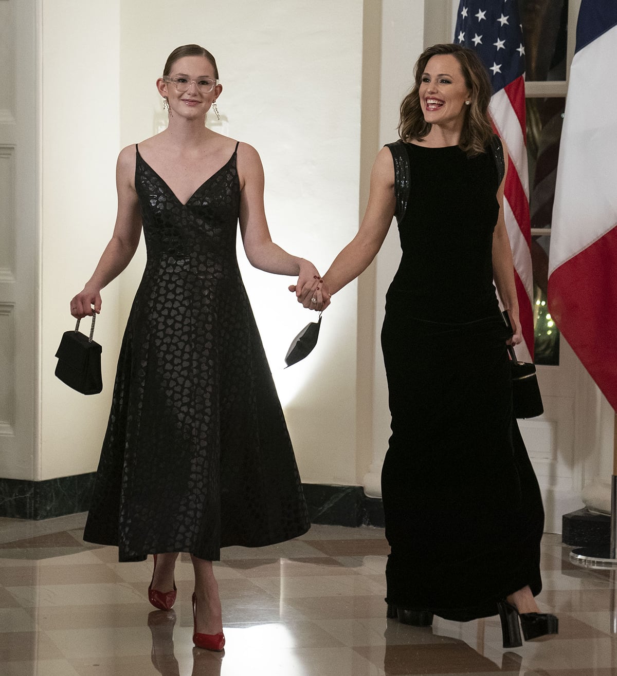 Violet Affleck pairs a black, V-neck midi dress with glossy red pointed-toe pumps, while mom Jennifer Garner complements her sleek black gown with towering black platform sandals