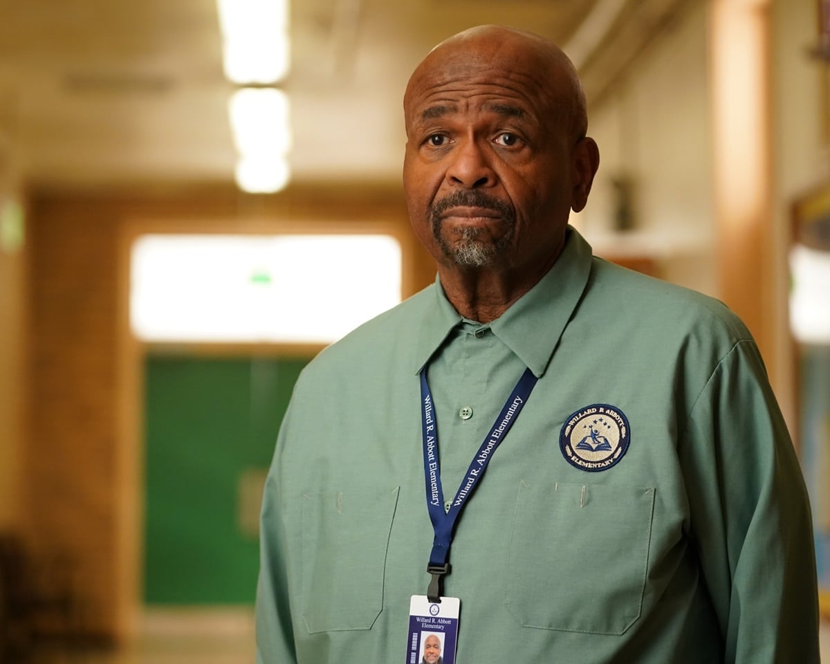 William Stanford Davis, who stands 5 feet 11 inches tall, portrays the conspiracy-loving custodian Mr. Johnson in his signature sage green uniform shirt and school ID badge at Willard R. Abbott Elementary