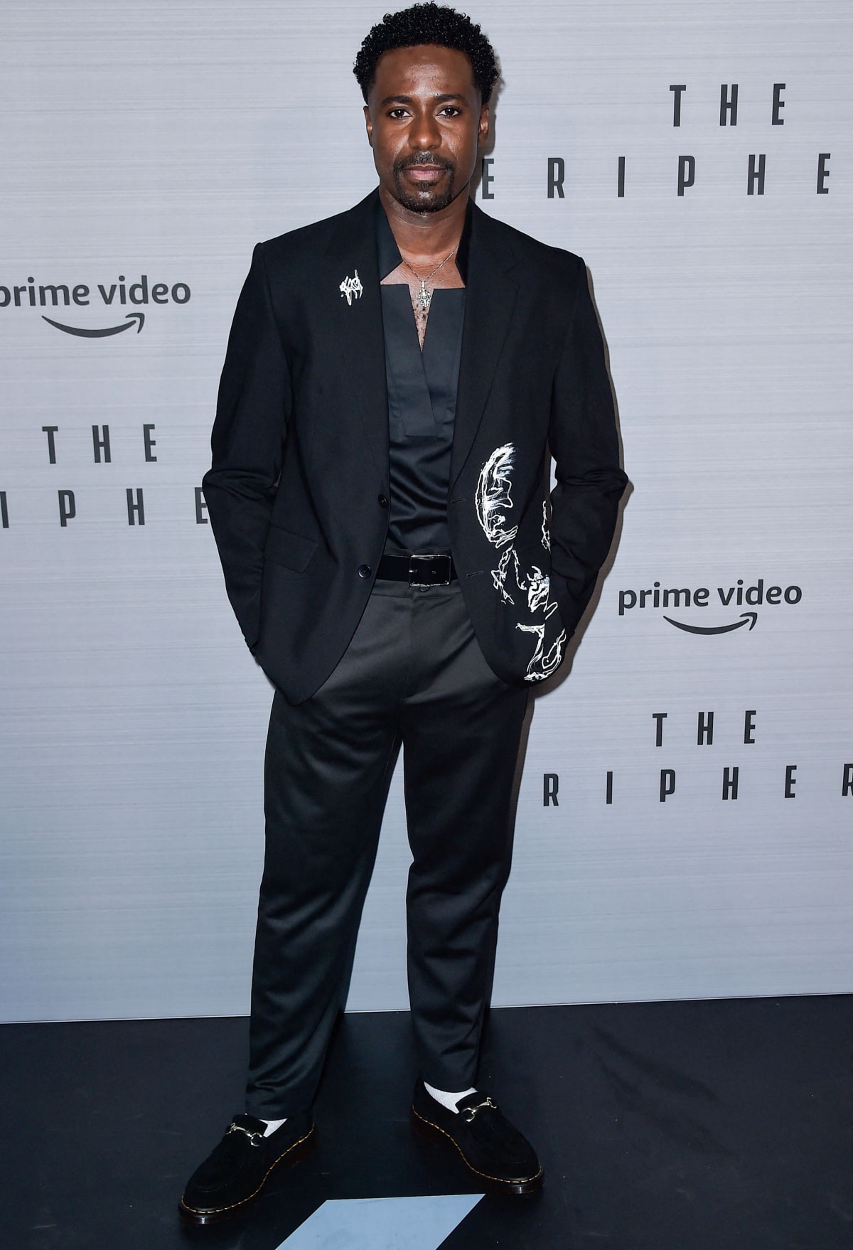 Gary Carr exuded effortless sophistication at The Peripheral Los Angeles premiere, wearing a sleek black suit with artistic white embroidery and classic loafers that added a polished, fashion-forward edge