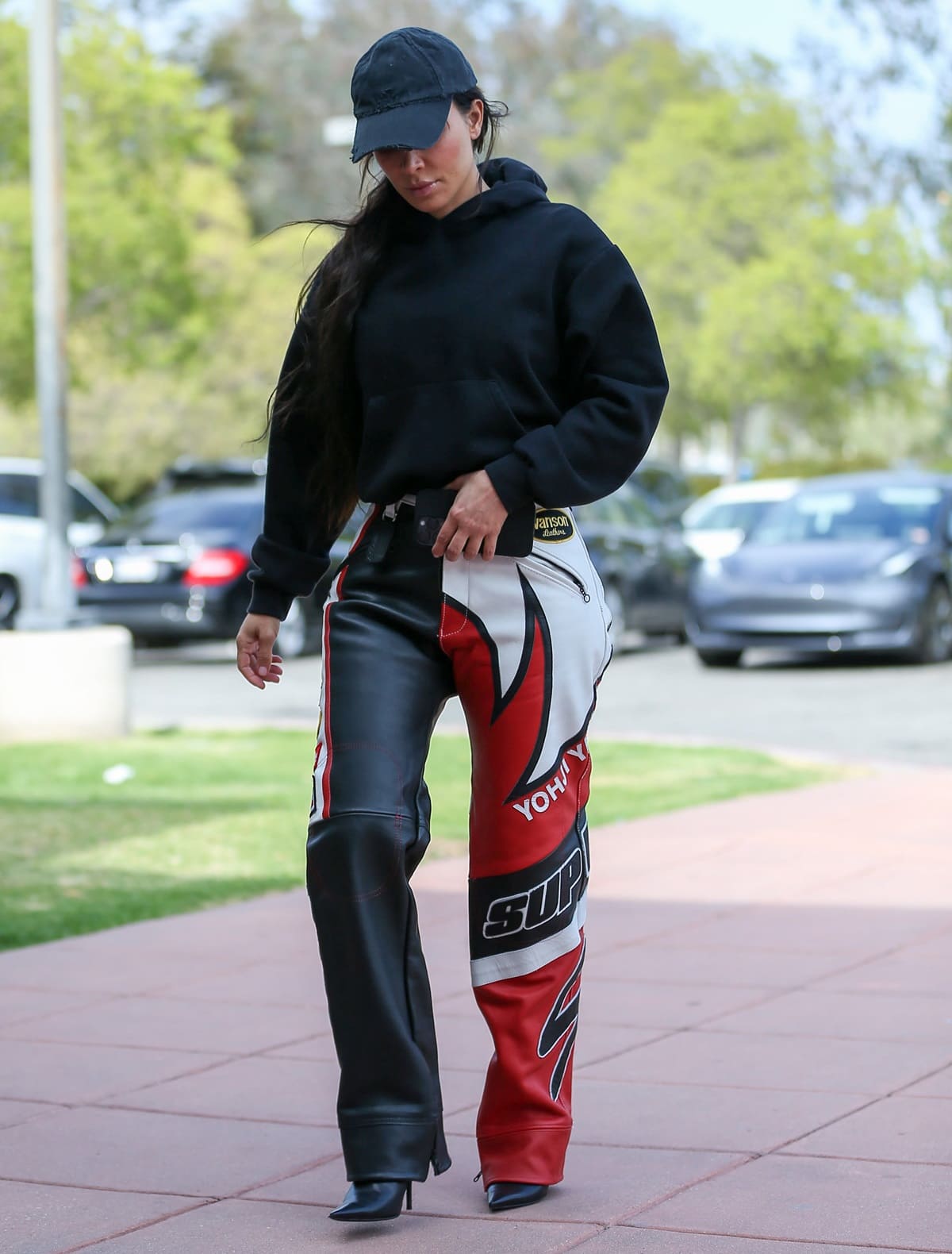 Kim Kardashian steps out in Los Angeles on May 19, 2023, wearing leather motorcycle pants from the Supreme x Yohji Yamamoto Vanson collaboration, styled with a relaxed black Skims fleece hoodie and finished with sleek pointed-toe black heels