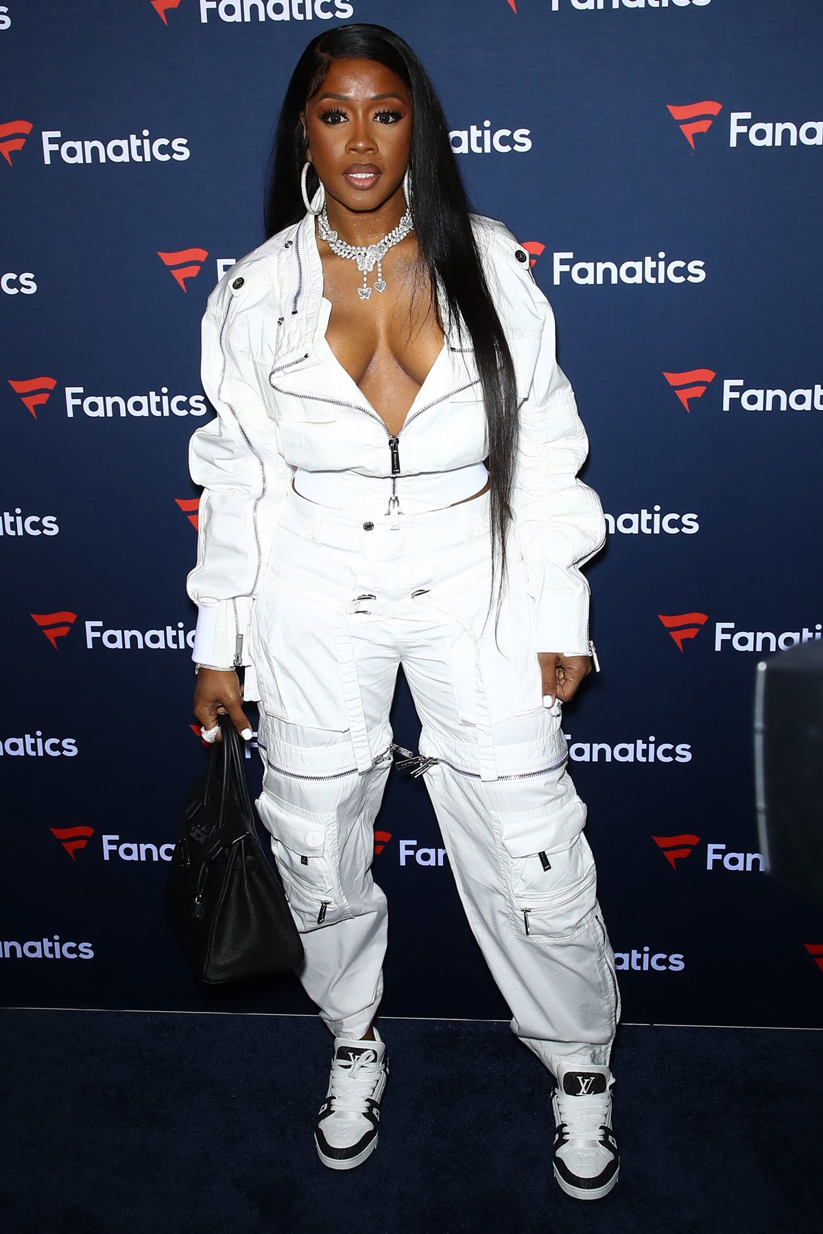Remy Ma rocked an edgy all-white zip-front cargo jumpsuit with Louis Vuitton sneakers and a structured black handbag at Michael Rubin's Fanatics Super Bowl Party in Las Vegas on February 10, 2024