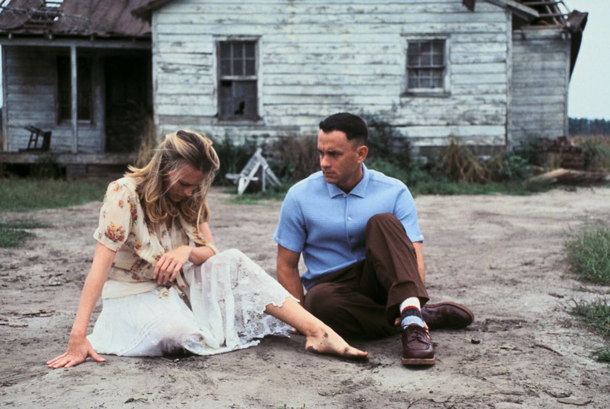 Robin Wright as Jenny Curran sits barefoot beside Tom Hanks as Forrest Gump, her undone appearance and lack of shoes underscoring Jenny’s vulnerability and free-spirited nature
