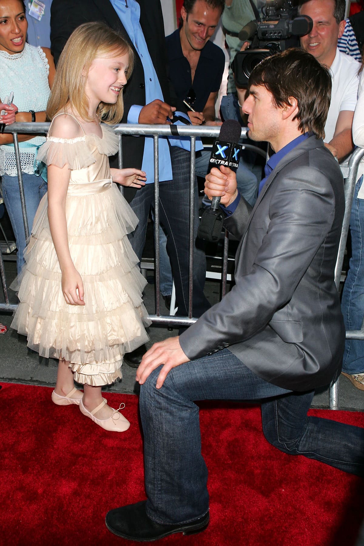 Dakota Fanning looked adorable in a tiered tulle dress and blush ballet flats, while Tom Cruise kept it casual yet polished in a gray blazer, dark jeans, and black boots at the War of the Worlds premiere