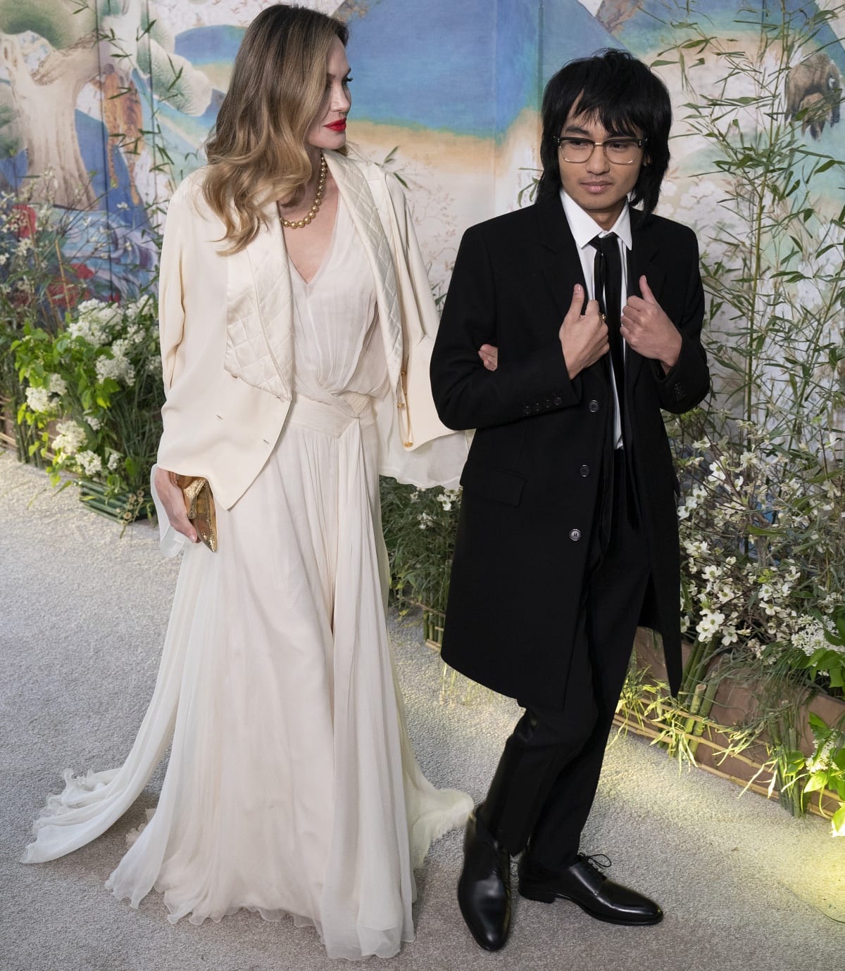 Angelina Jolie glowed in an ivory gown and quilted Chanel jacket paired with bronze metallic pointed-toe heels, while her son Maddox Jolie-Pitt complemented her refined palette in a sharp black suit, polished dress shoes, and slim tie at the White House State Dinner celebrating the U.S.–ROK alliance