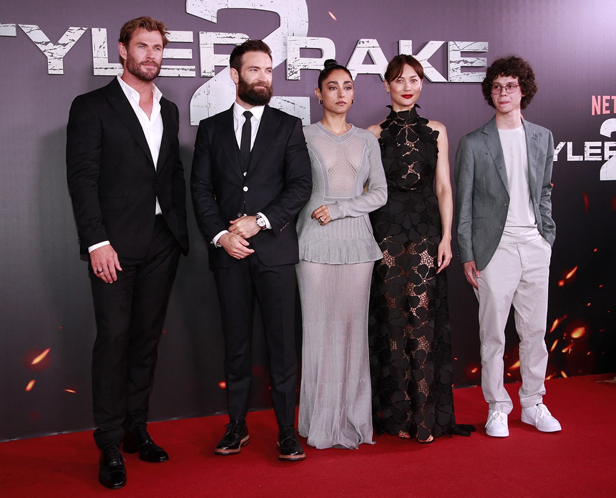 Chris Hemsworth steps out in a tailored Etro suit with polished dress shoes alongside director Sam Hargrave, Golshifteh Farahani in Givenchy, and Olga Kurylenko in an Elie Saab gown styled with Jimmy Choo sandals at the Extraction 2 Madrid premiere