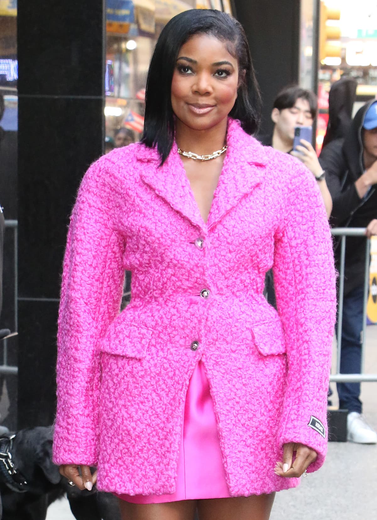 Gabrielle Union pairs her pink ensemble with a Tiffany Co. chain link necklace, a side-swept hairstyle, and nude lip gloss