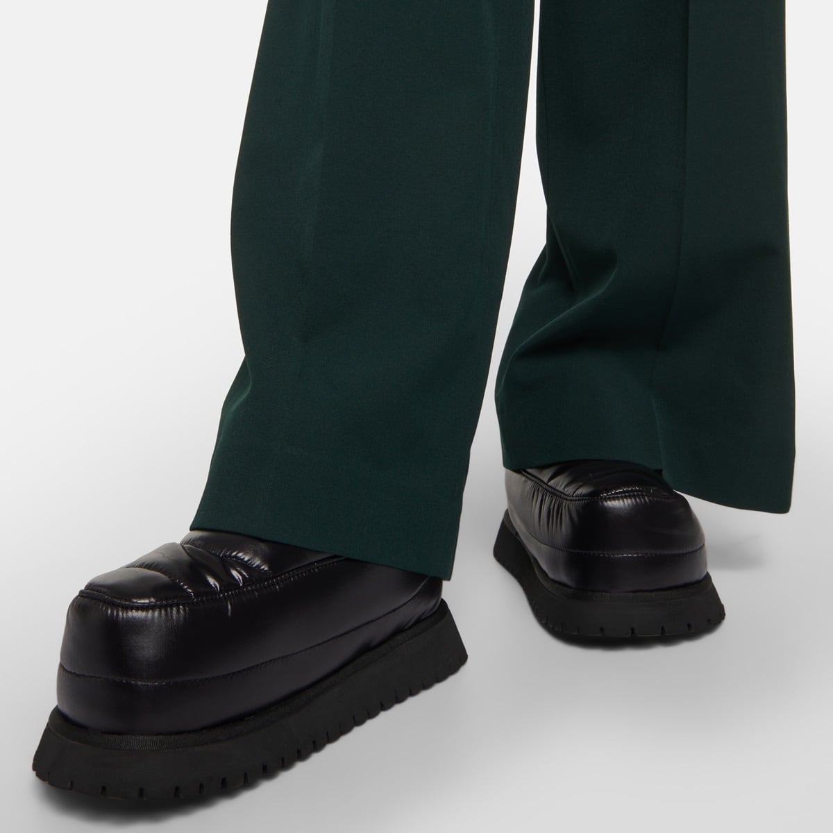 These ankle boots, featuring a rounded toe and cushioned design, boast a substantial rubber sole and a slip-on construction, ensuring effortless wearability