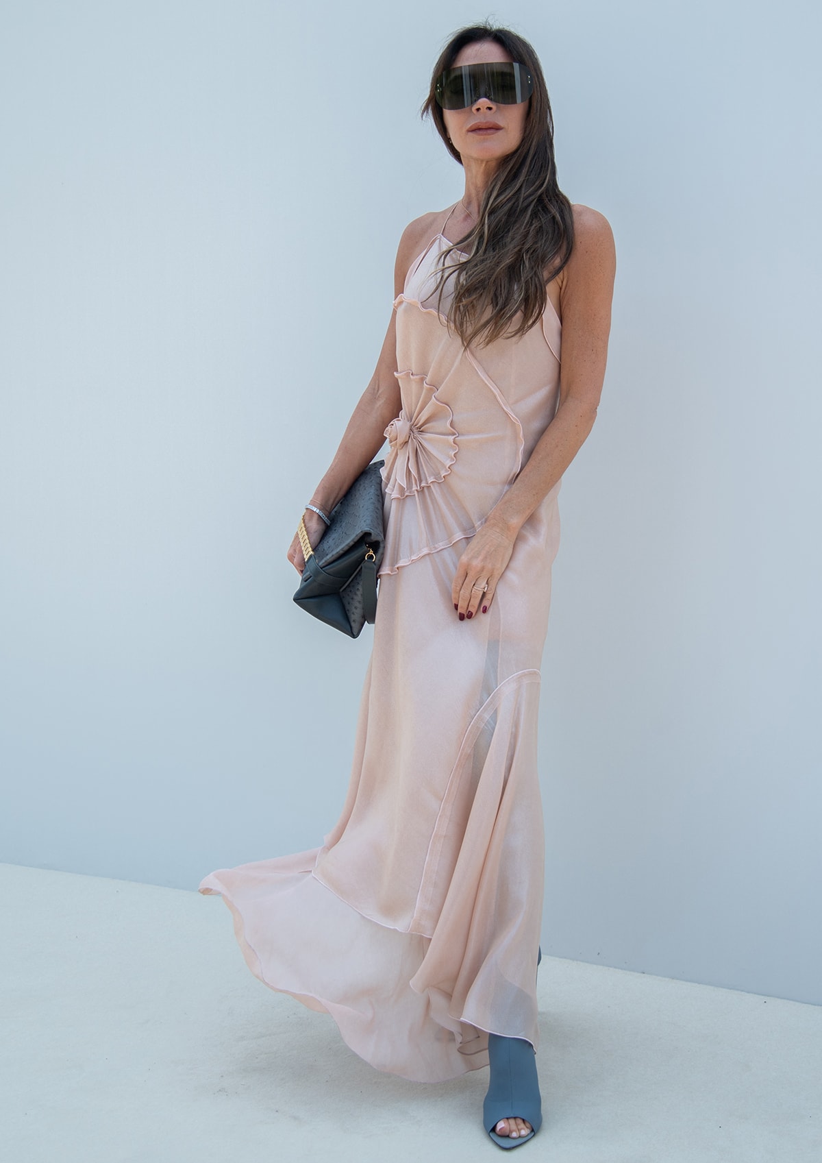 Victoria Beckham wears a pale pink asymmetrical slip dress with dark thigh-high peep-toe stiletto boots at Versailles