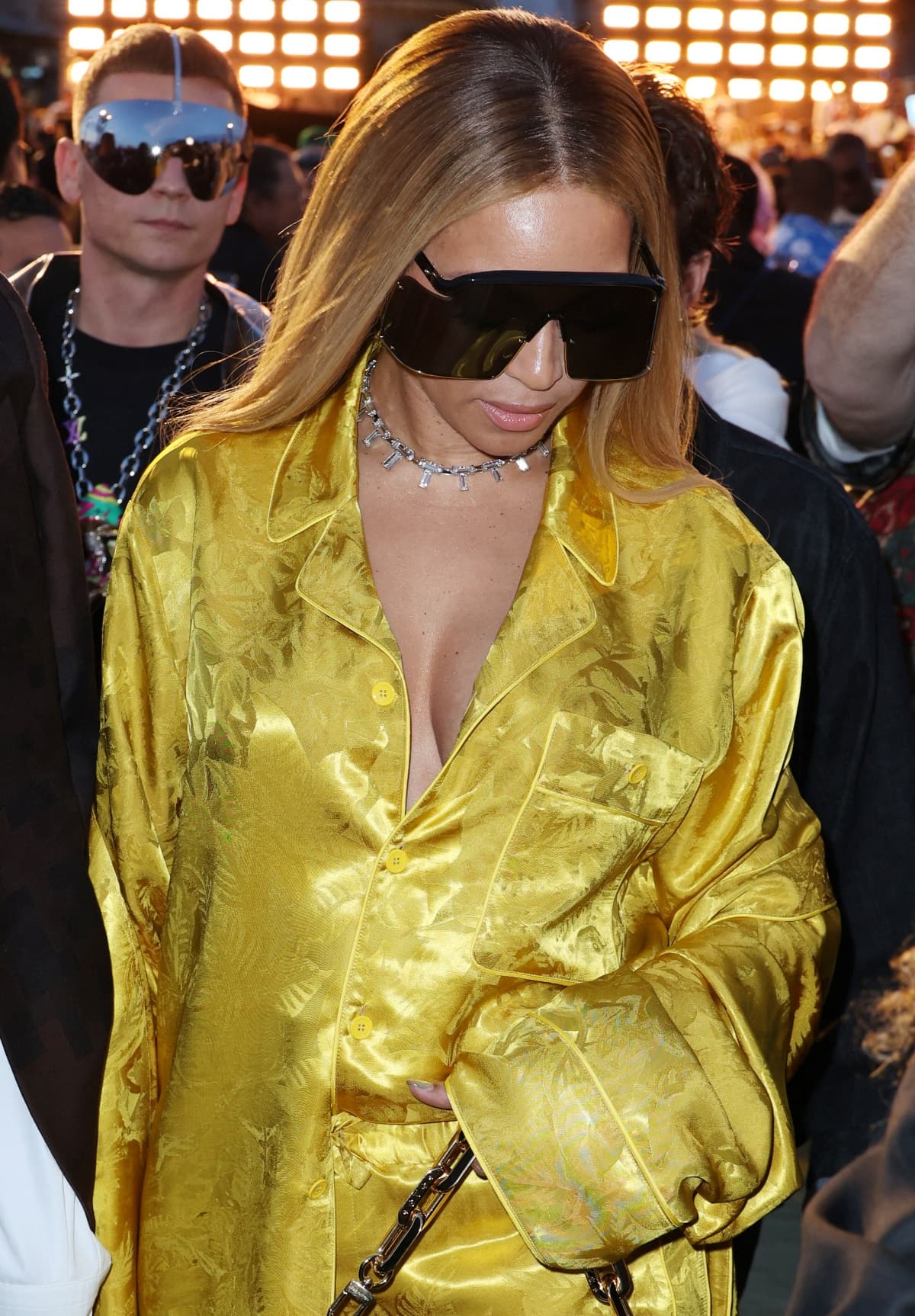 Beyonce wearing a custom golden pajama set from Louis Vuitton accessorized with oversized shield sunglasses, a diamond choker, and a Tiffany Co. ring