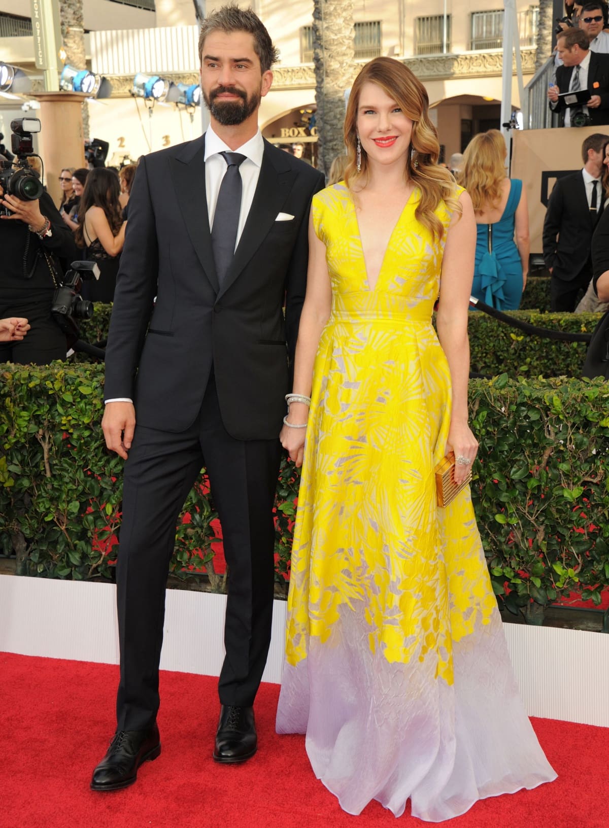 Lily Rabe glowed at the 2016 Screen Actors Guild Awards in a yellow-and-lavender ombré Lela Rose gown, paired with Stuart Weitzman heels, a Lee Savage clutch, and Lorraine Schwartz jewelry, while Hamish Linklater complemented her look in a classic black suit and tie