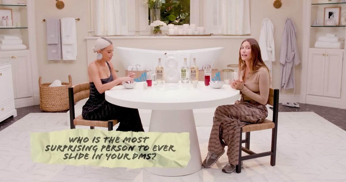Kim Kardashian kept it sleek in a black Balenciaga jumpsuit with pointy-toe heels, while Hailey Bieber paired a fitted beige top with Balenciaga BB Monogram cargo pants and gray New Balance 574 sneakers as they discussed surprising DMs on her YouTube show