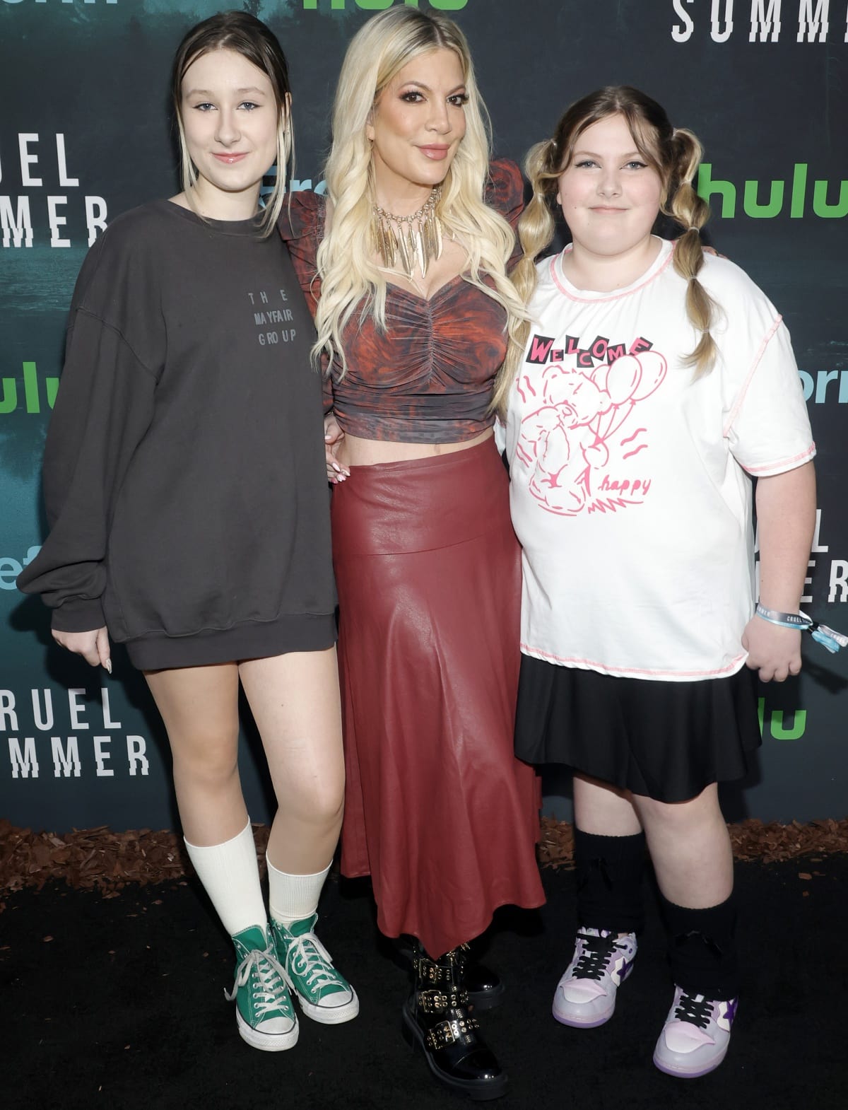 Tori added edge in a red leather skirt, ruched crop top, and black studded combat boots, while Stella kept it casual in green Converse high-top sneakers with a sweatshirt dress, and Hattie showed off playful purple lace-up sneakers with a graphic tee and skirt