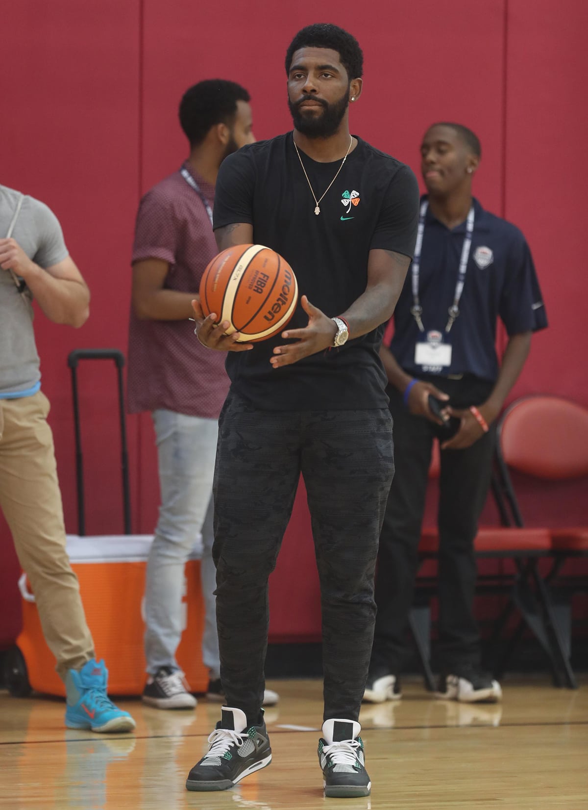 Kyrie Irving, now playing for the Dallas Mavericks, is seen at the 2018 USA Basketball Camp wearing a black Nike tee, camo joggers, and Air Jordan 4 sneakers—years before his Nike contract ended in 2022 and his move to Anta Sports signaled a new era in his sneaker journey