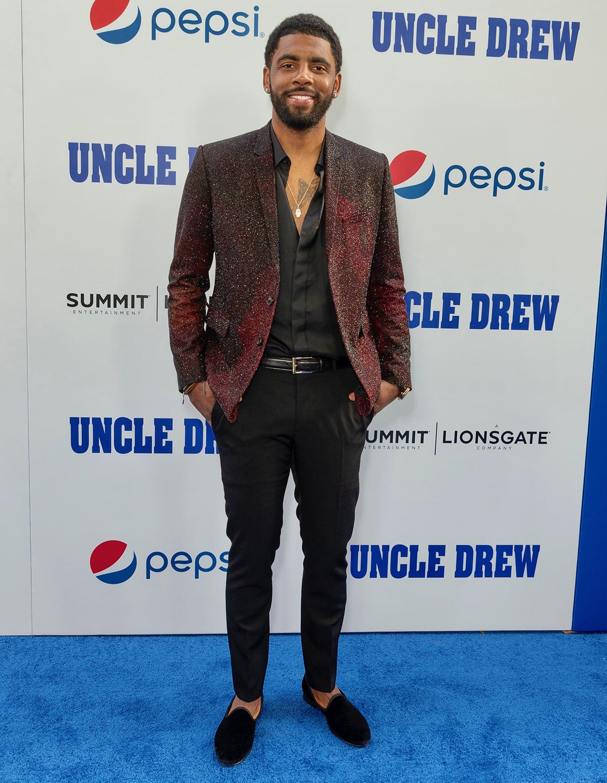 Kyrie Irving, an eight-time NBA All-Star and former Rookie of the Year, attends the Uncle Drew premiere in a shimmering burgundy suit jacket, black shirt, and velvet loafers—showcasing his off-court flair and signature mix of polish and personality