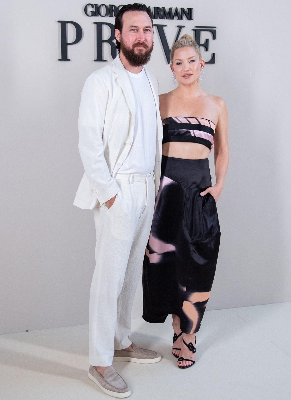Danny Fujikawa complemented Kate Hudson’s look in a relaxed cream Armani suit, grounding the tonal ensemble with gray velvet loafers that added subtle texture and contrast to the otherwise crisp monochrome palette