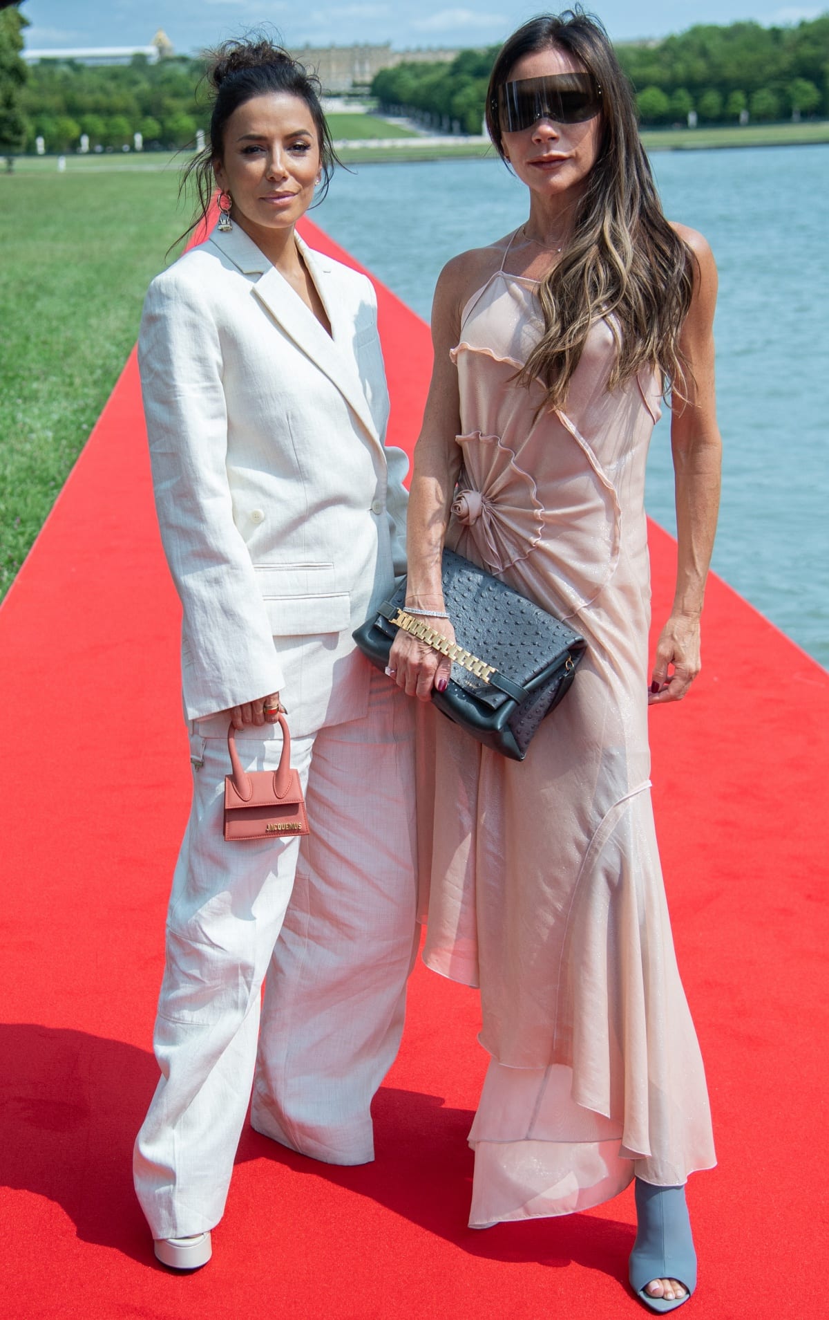 Eva Longoria and Victoria Beckham posing for photos together on the red carpet at the Jacquemus Menswear Spring/Summer 2024 show during Paris Fashion Week