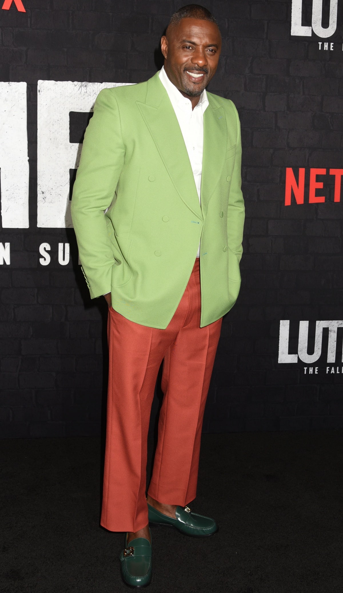 Idris Elba makes a bold statement at the Luther: The Fallen Sun premiere, pairing a lime green double-breasted blazer and rust trousers with glossy green Gucci loafers featuring signature horsebit hardware