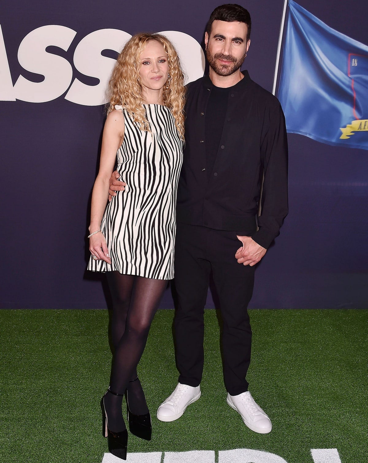 Juno Temple channels playful elegance in a zebra-print mini dress paired with black tights and towering Valentino platform heels as she poses with her taller Ted Lasso co-star Brett Goldstein