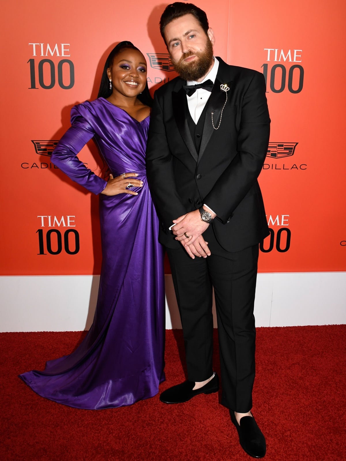 Quinta Brunson radiated elegance in a rich purple satin gown with ruched detailing and pointed-toe heels, while husband Kevin Jay Anik looked dapper in a classic black tuxedo and velvet loafers at the TIME 100 Gala