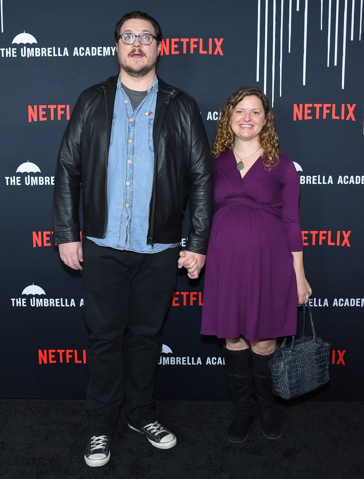 Pictured with his wife, Calith Ferrante, Cameron Britton embraced a laid-back look in black jeans, classic Converse sneakers, and a leather jacket at The Umbrella Academy premiere, towering stylishly over the carpet