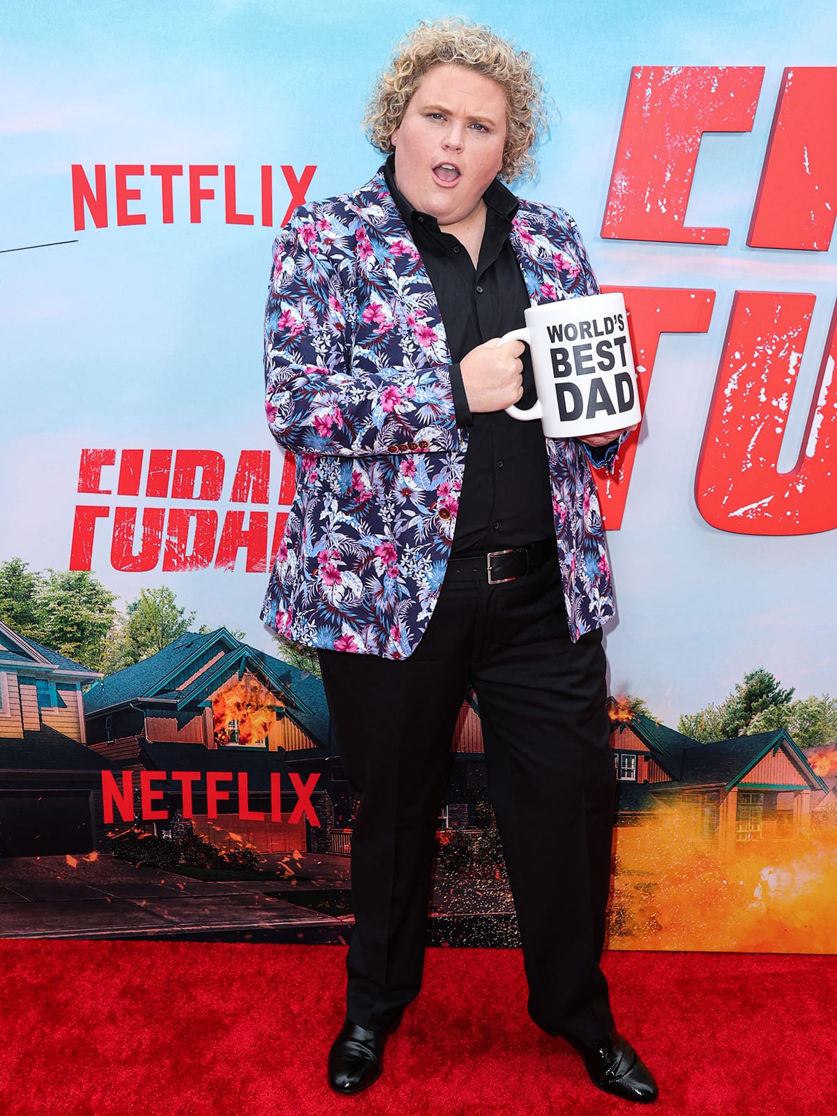Fortune Feimster brought playful energy to the FUBAR premiere in a vibrant floral blazer, black button-down and trousers, and classic black dress shoes—topped off with a cheeky “World’s Best Dad” mug for good measure
