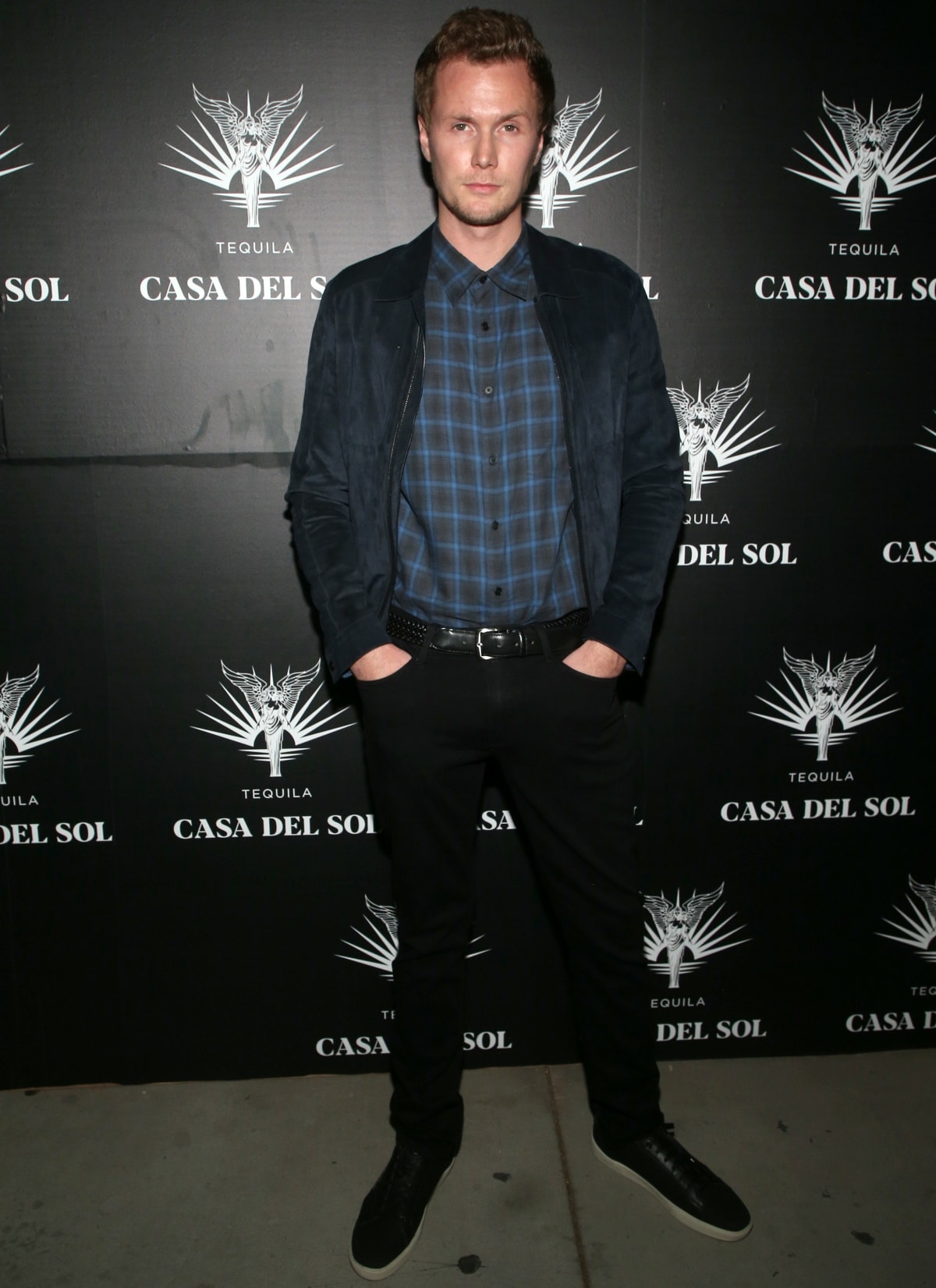 Barron Hilton II keeps it casual in a blue plaid shirt, black jeans, and sleek black sneakers at Brian Bowen Smith’s Drivebys book launch and gallery viewing, presented by Casa Del Sol Tequila in Los Angeles on October 21, 2021