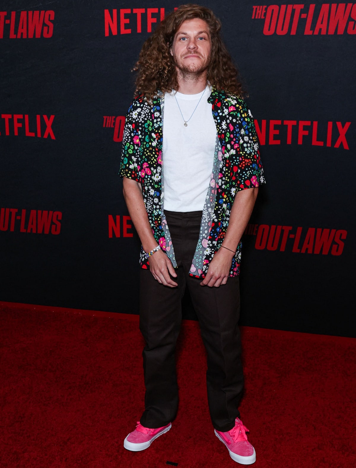 Blake Anderson keeps it cool and casual at The Out-Laws premiere, sporting a playful floral shirt, relaxed pants, and bold pink sneakers that add a pop of color to his laid-back look