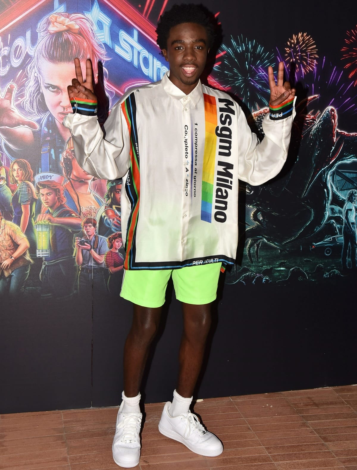 Caleb McLaughlin brought vibrant street style to the Stranger Things event in a bold MSGM Milano shirt, neon green shorts, and crisp white sneakers that kept the look youthful and energetic