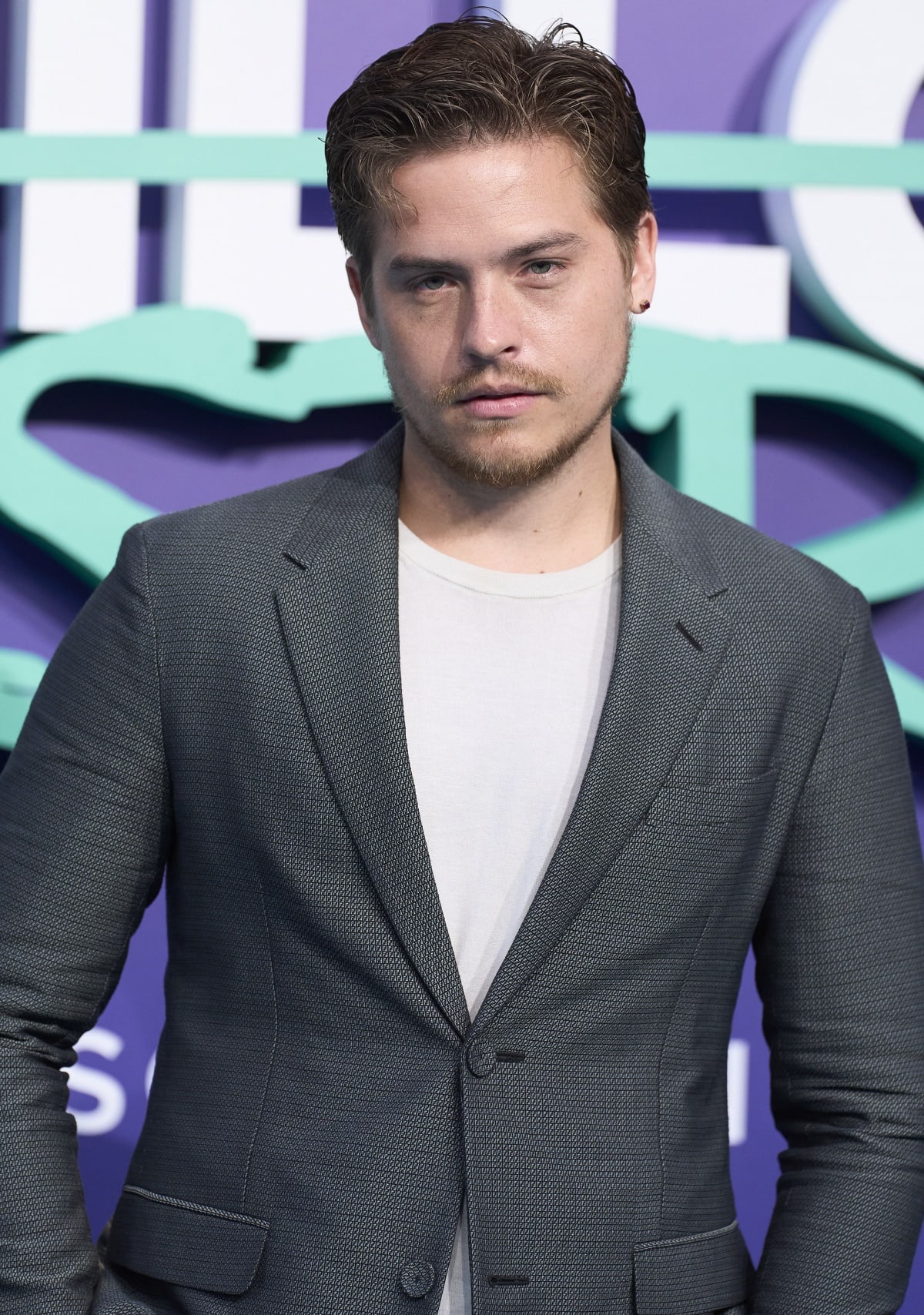Dylan Sprouse keeps it sharp and modern in a textured slate-grey blazer layered over a crisp white tee at the Beautiful Disaster premiere in Madrid, Spain on March 29, 2023