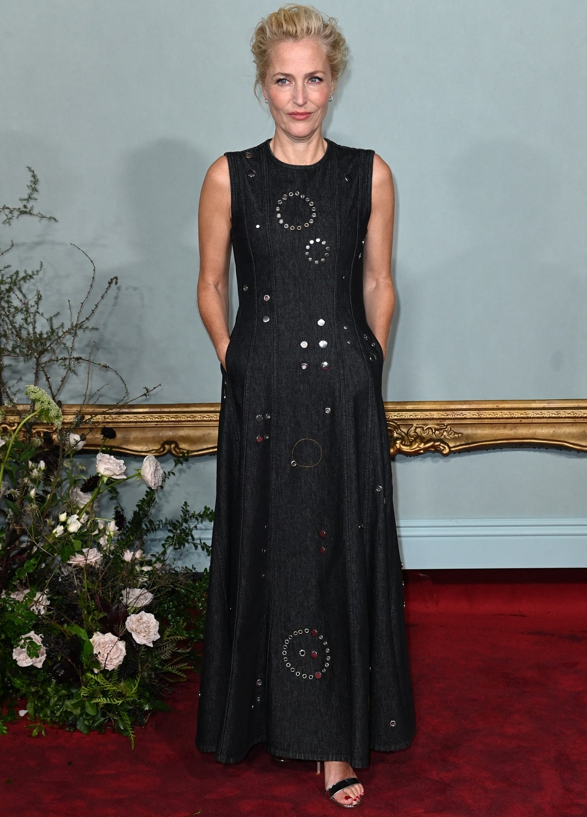 Gillian Anderson exuded understated elegance in a sleeveless black studded gown paired with minimalist black stiletto sandals, adding a touch of edge to her refined red carpet look