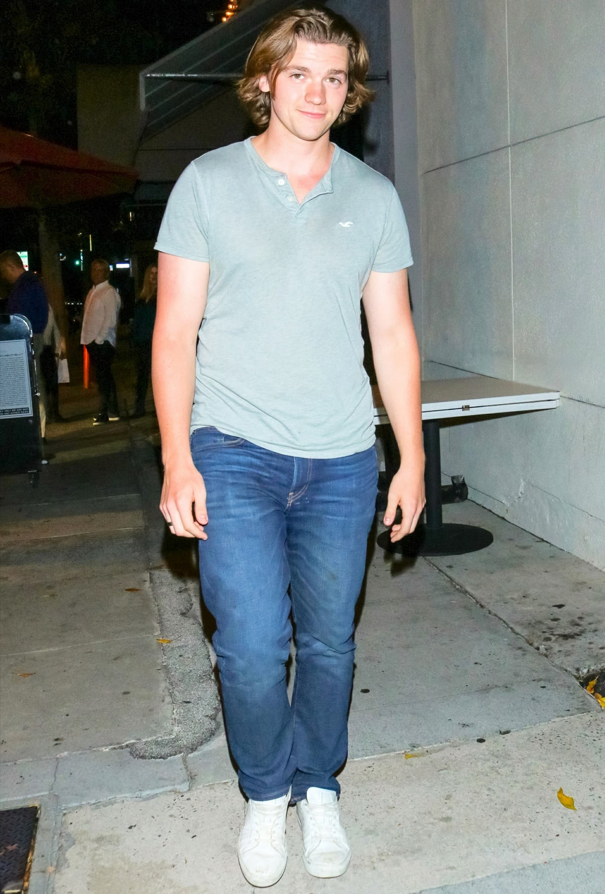 Joel Courtney embraces a relaxed street-style look with fitted jeans paired with clean white low-top sneakers