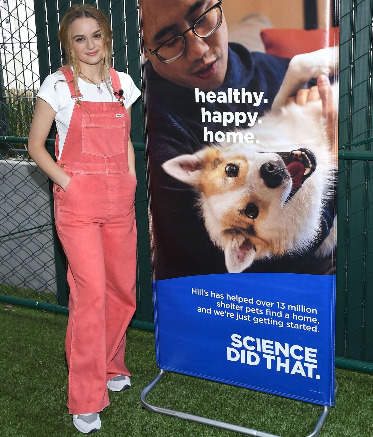 Joey King keeps it casual in pink overalls and classic white sneakers while supporting a pet adoption event