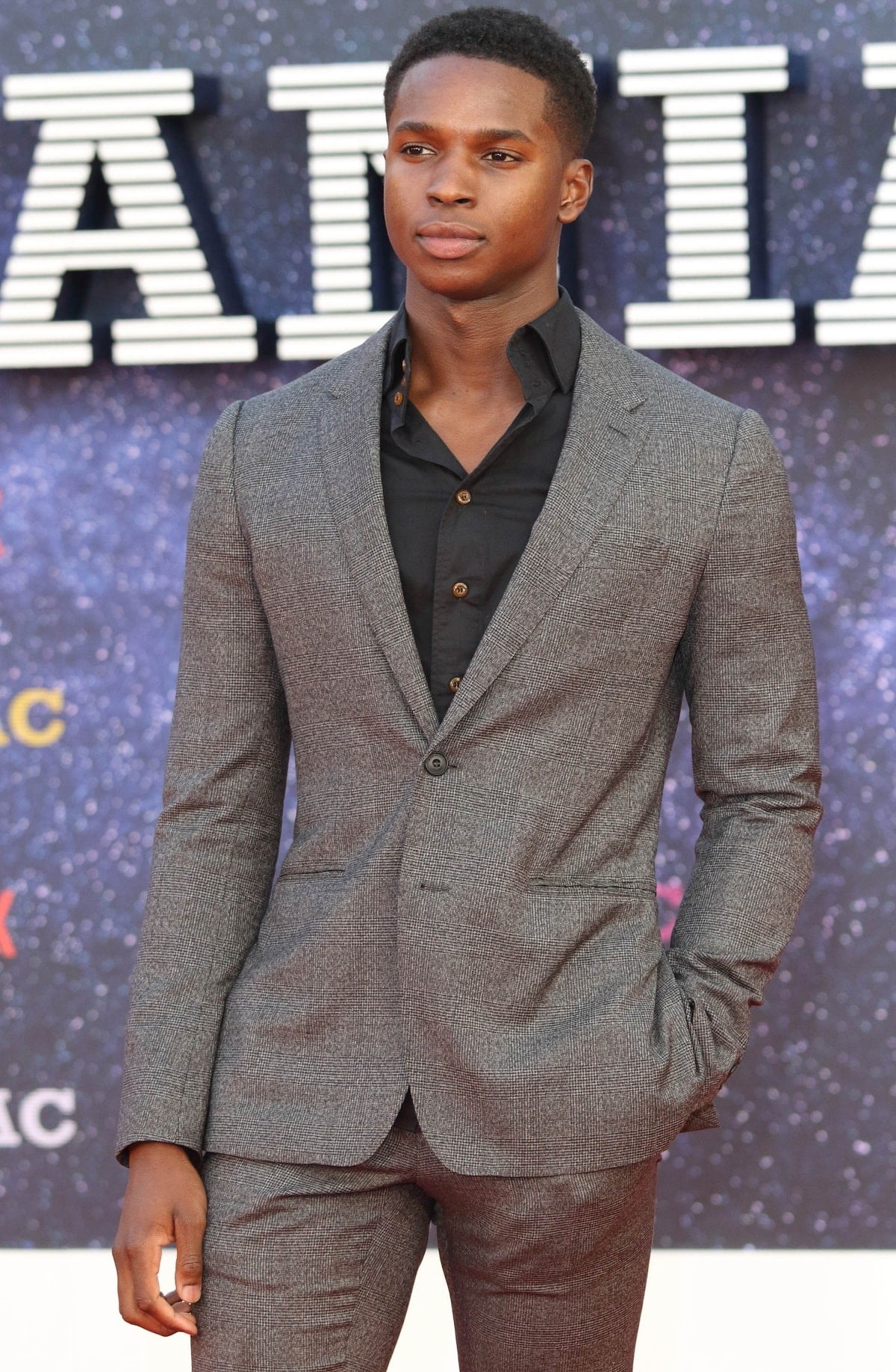 Kedar Williams-Stirling kept it sharp and sophisticated in a tailored grey check suit paired with a classic black button-down shirt