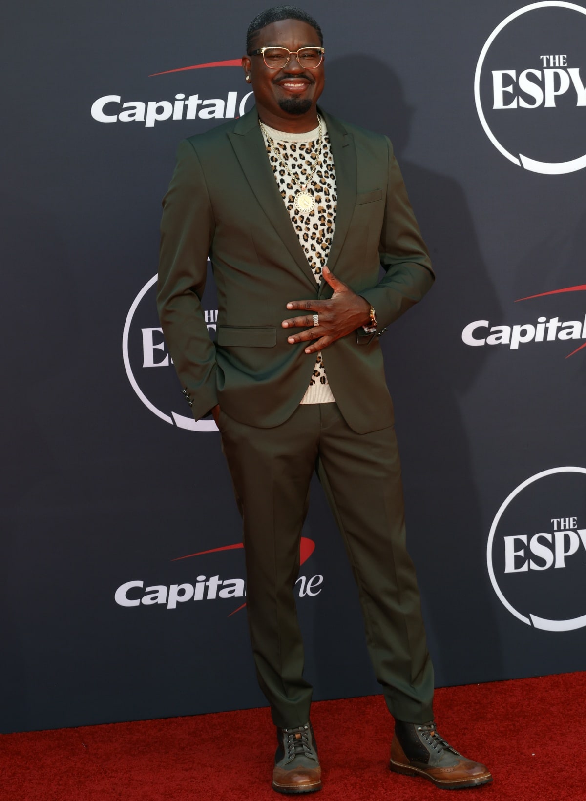 Lil Rel Howery stands out at the 2023 ESPY Awards, rocking an olive green suit paired with a bold leopard-print shirt and stylish two-tone boots for a confident, unique look