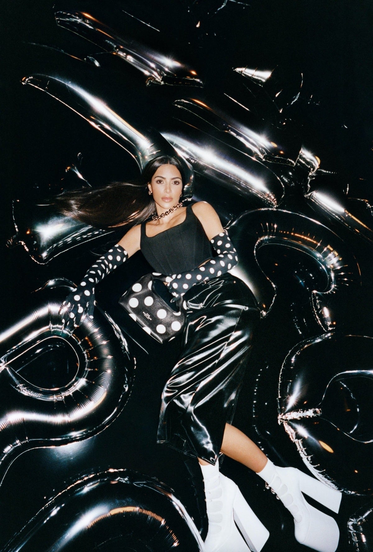 The Kim Kardashian for Marc Jacobs Fall 2023 images are playful and eclectic, with the reality television star posing in oversized polka dot dresses, platform heels, and leather jackets