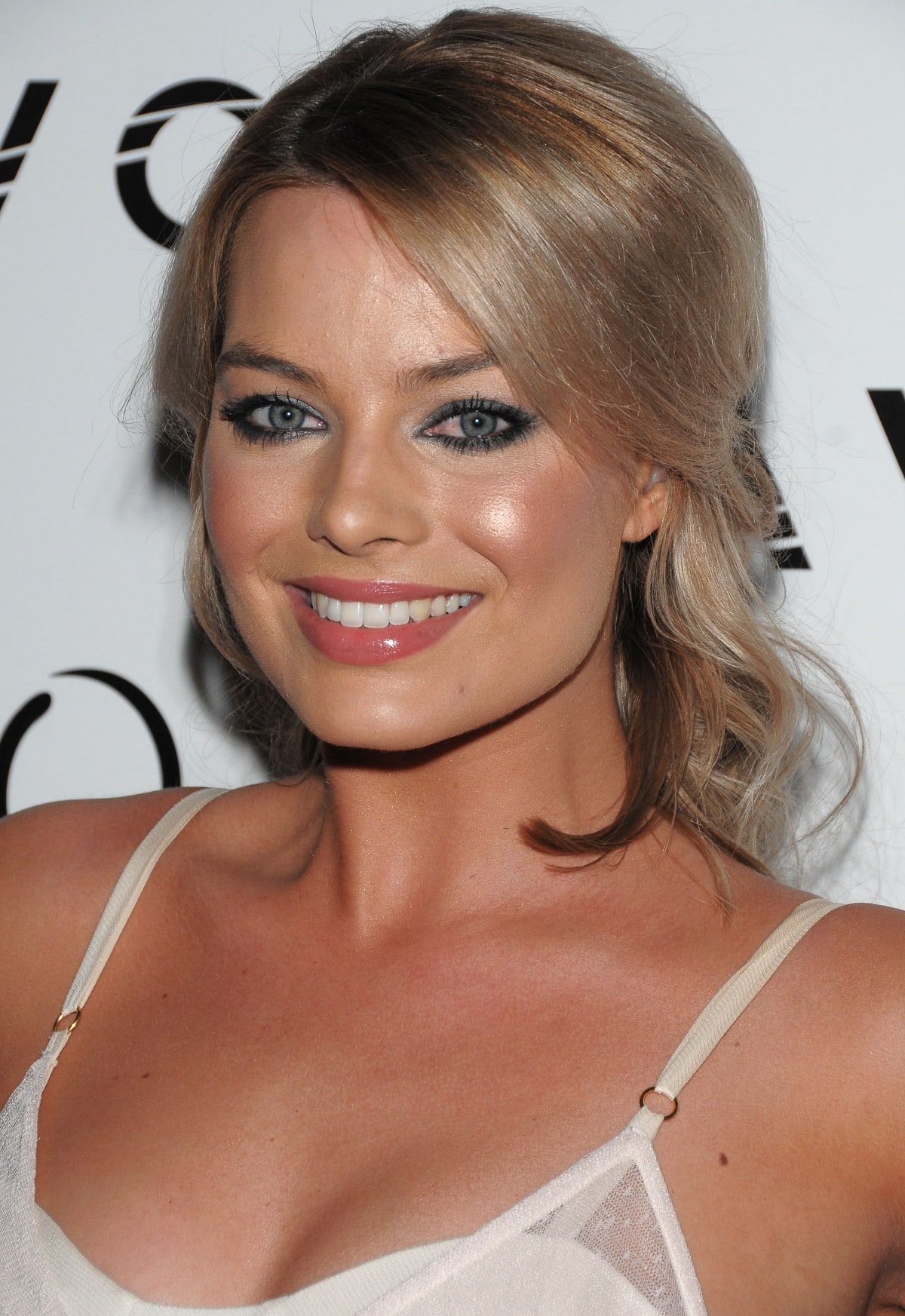 Glowing with youthful radiance, Margot Robbie turned heads with voluminous lashes, shimmering smoky eyeshadow, and glossy pink lips—her tousled blonde waves and confident smile completing the fresh, red carpet-ready look