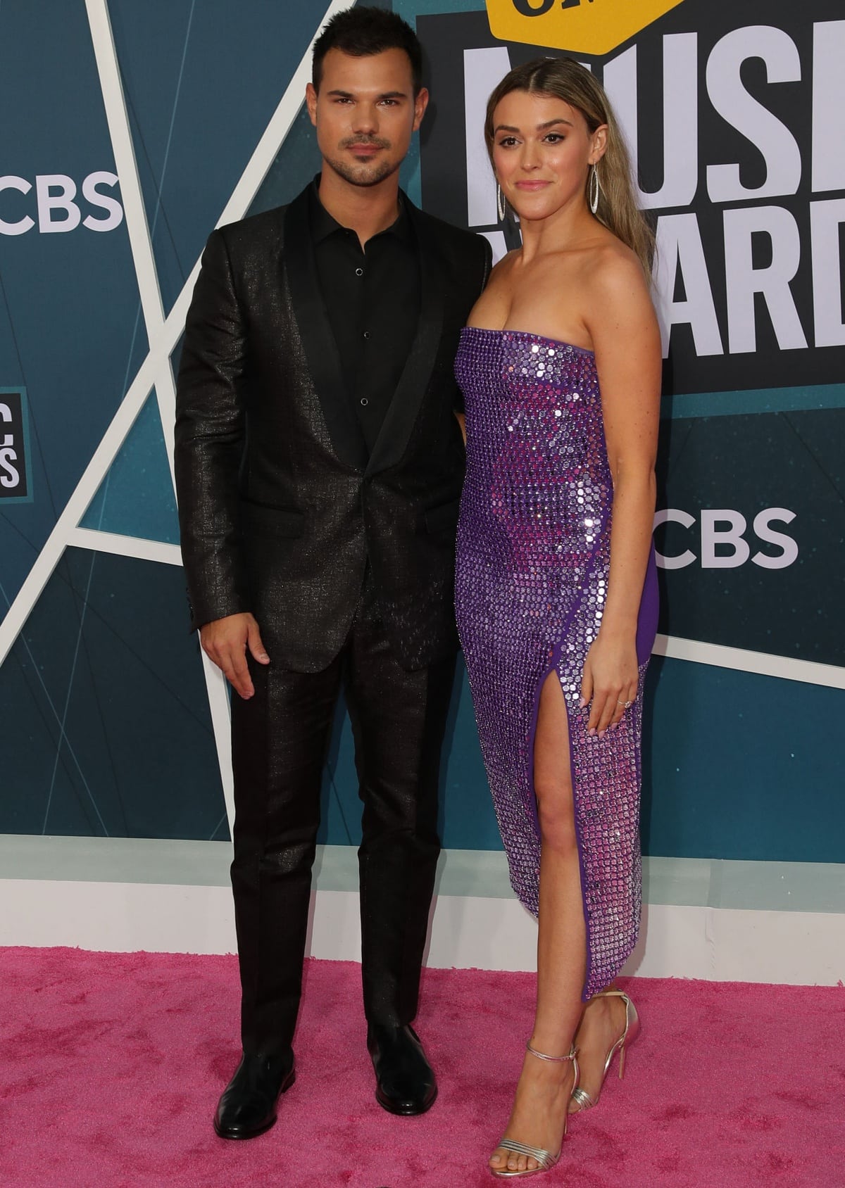 Taylor Lautner and Taylor Dome turned heads at the CMT Music Awards, with Dome dazzling in a strapless sequin purple dress paired with silver metallic strappy sandals that elongated her legs