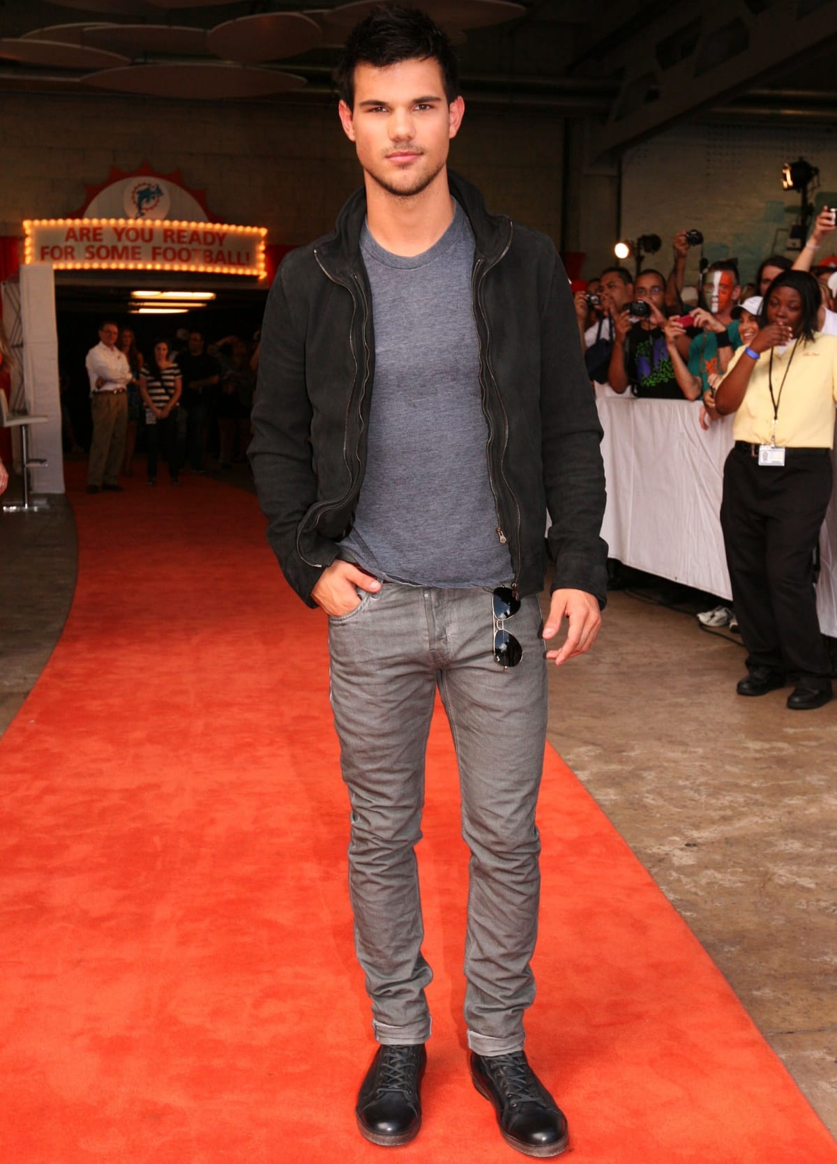 Taylor Lautner kept it casual on the red carpet in a fitted gray tee, slim gray jeans, and rugged black lace-up leather boots that added a touch of edge to his laid-back look