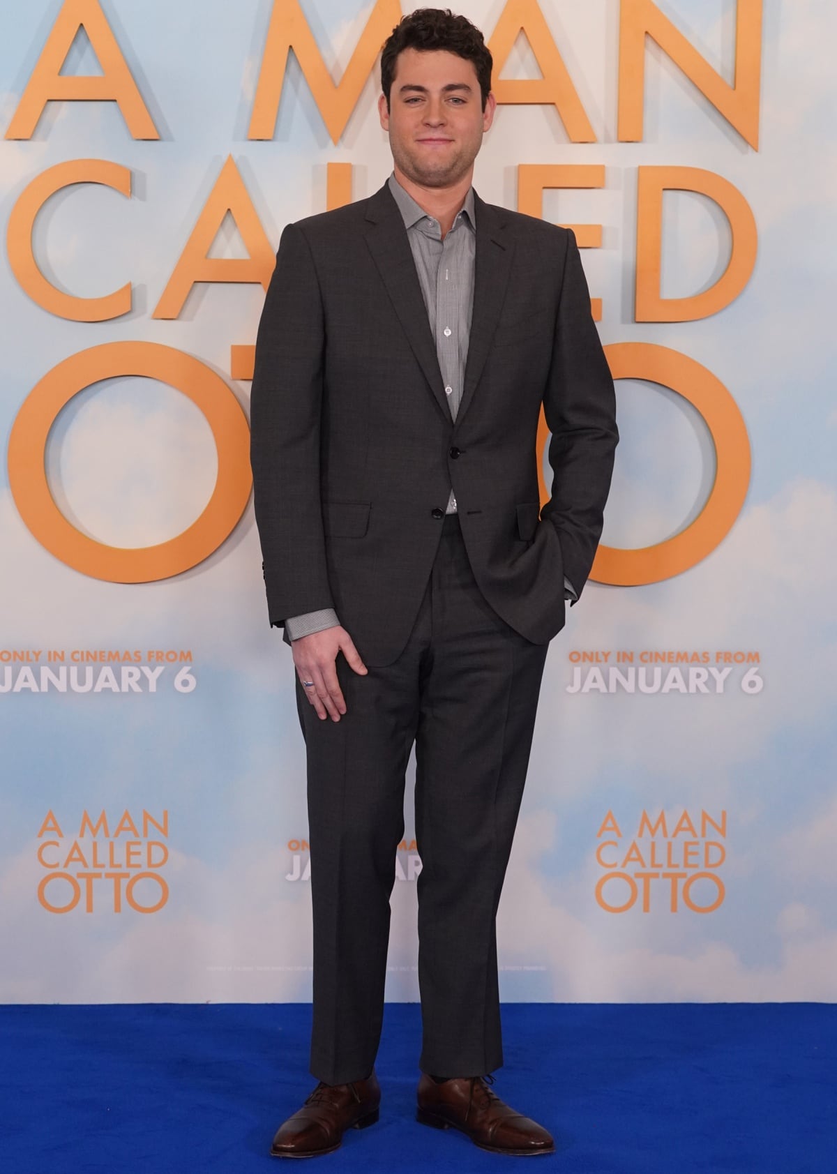 Standing at 5 feet 9 inches (175 cm), Truman Hanks looked polished in a charcoal suit paired with classic brown lace-up dress shoes at the A Man Called Otto premiere, embracing understated elegance on the blue carpet