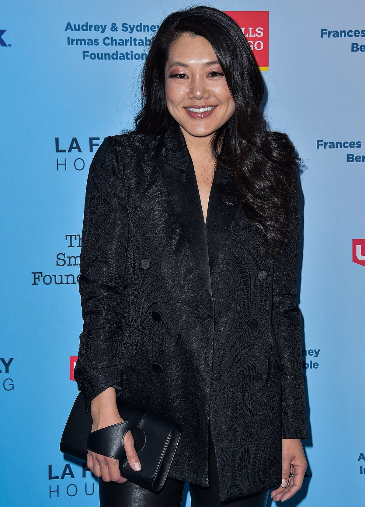 Crystal Kung Minkoff keeps it chic in an embroidered black double-breasted blazer paired with sleek leather pants and a structured clutch at a charity event supporting LA Family Housing
