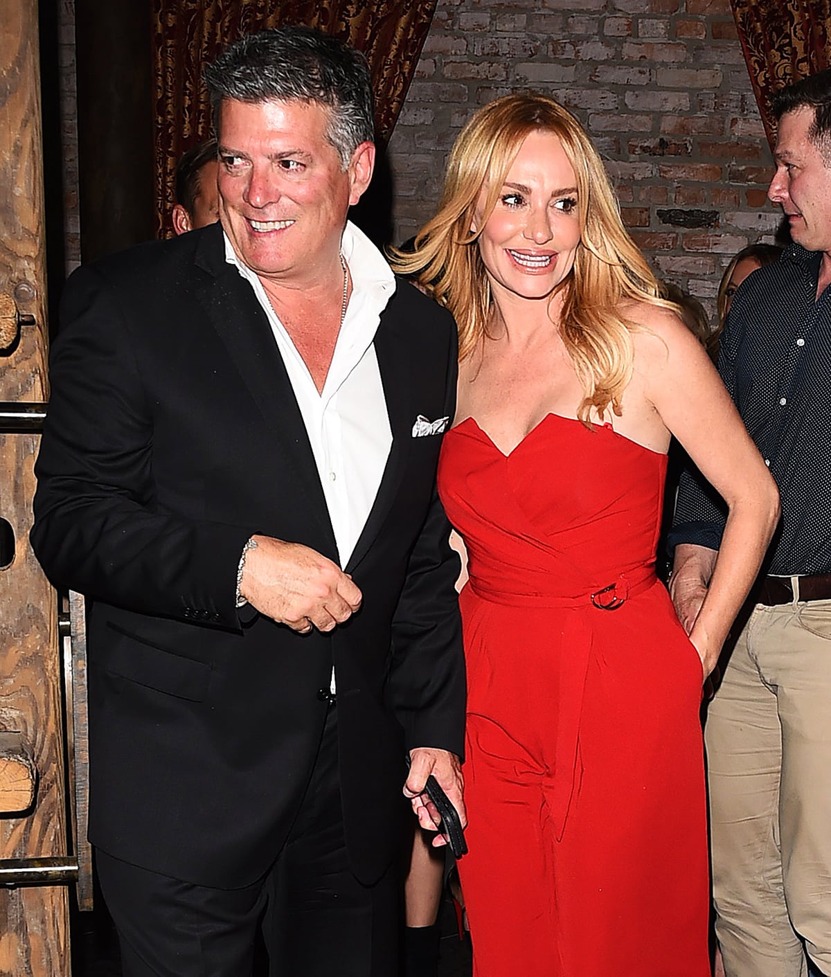 Taylor Armstrong radiates classic Hollywood charm in a strapless red belted gown as she enjoys a glamorous night out with husband John H. Bluher