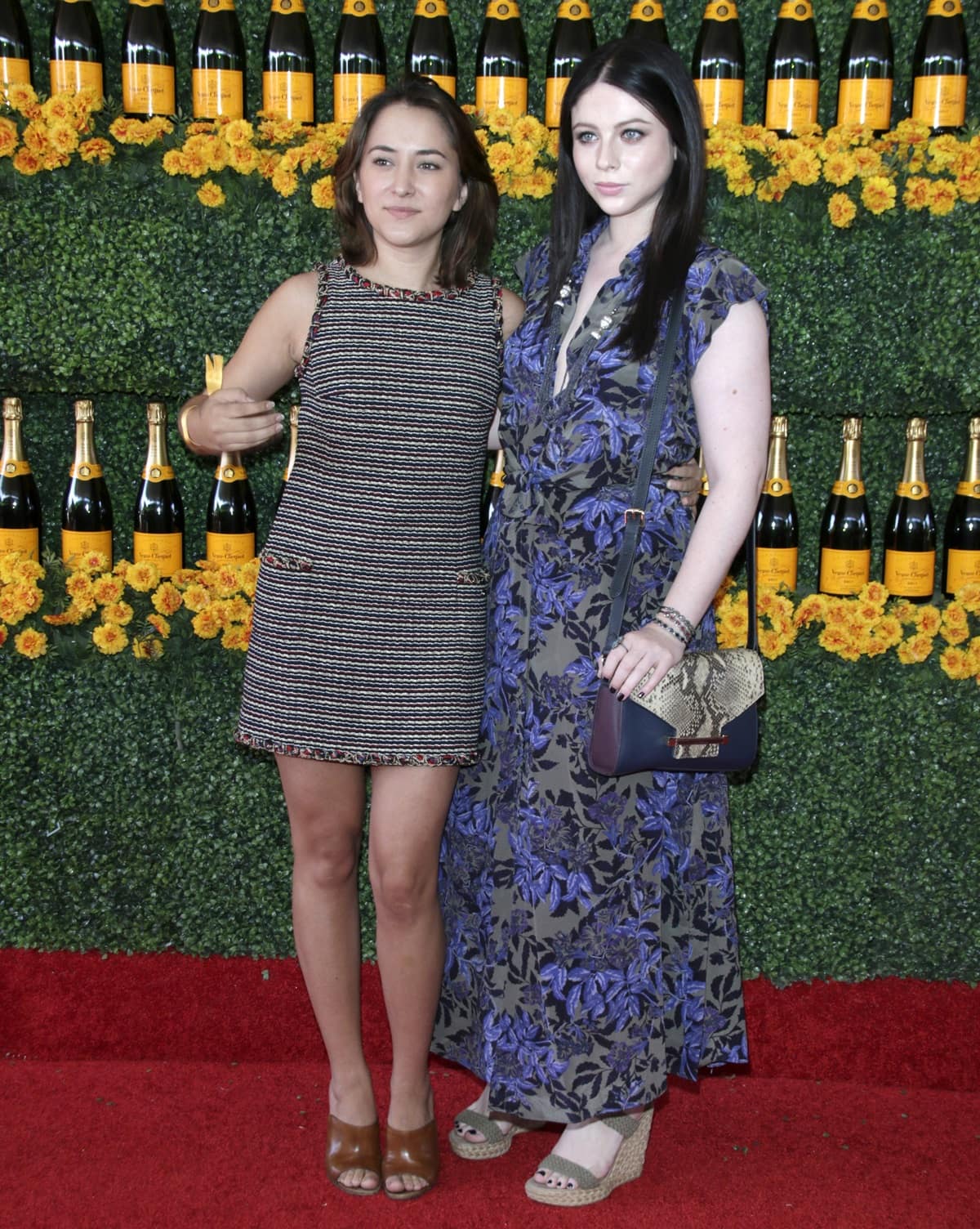 At the sixth-annual Veuve Clicquot Polo Classic in Pacific Palisades on October 17, 2015, Michelle Trachtenberg paired a flowing blue-and-black floral maxi dress with neutral wedge sandals and a snakeskin crossbody bag, while Zelda Williams contrasted the bohemian mood in a structured tweed mini dress styled with brown peep-toe heels