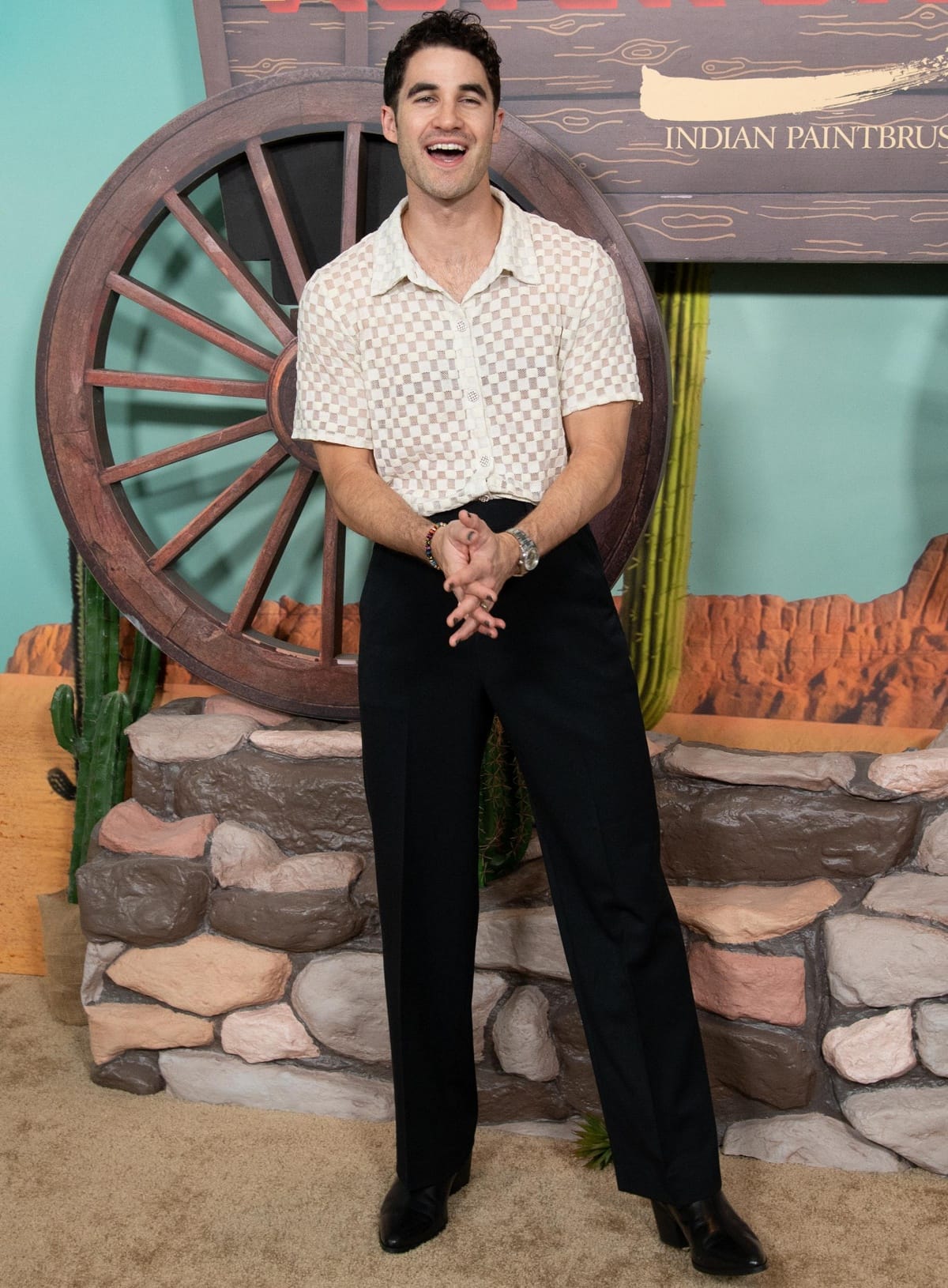 Darren Criss embraced retro flair in a sheer checkered shirt and high-waisted trousers, elevating the look with pointed black heeled boots that added a stylish lift to his petite 5'7½" frame