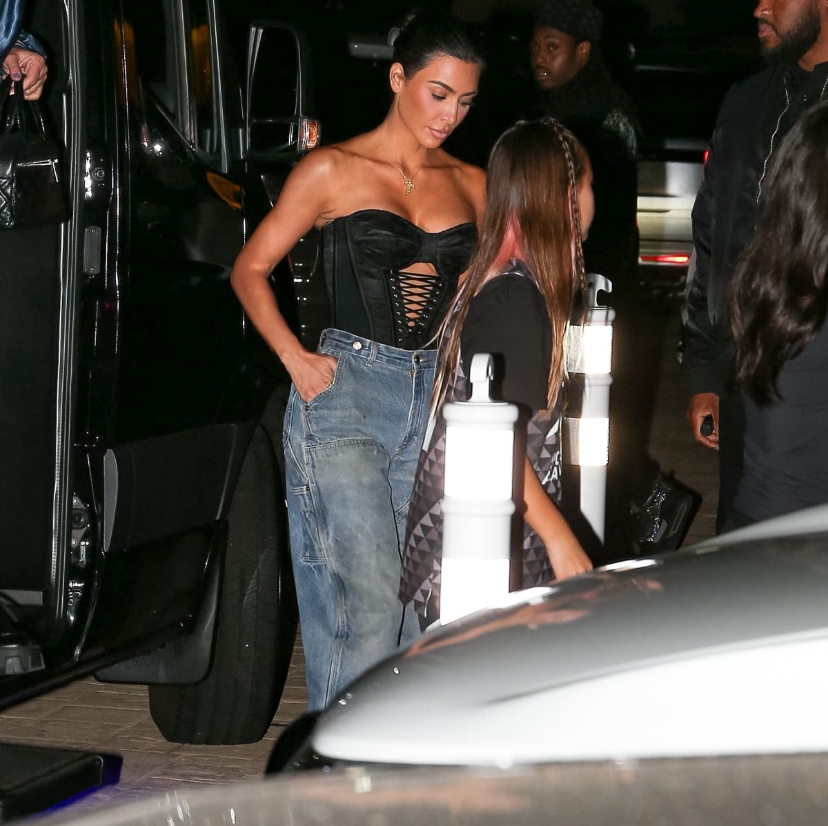 Kim Kardashian slipped into a sultry black strapless corset-style top with lace-up details, pairing it with her relaxed vintage Carhartt jeans for a chic outfit change at dinner in Malibu