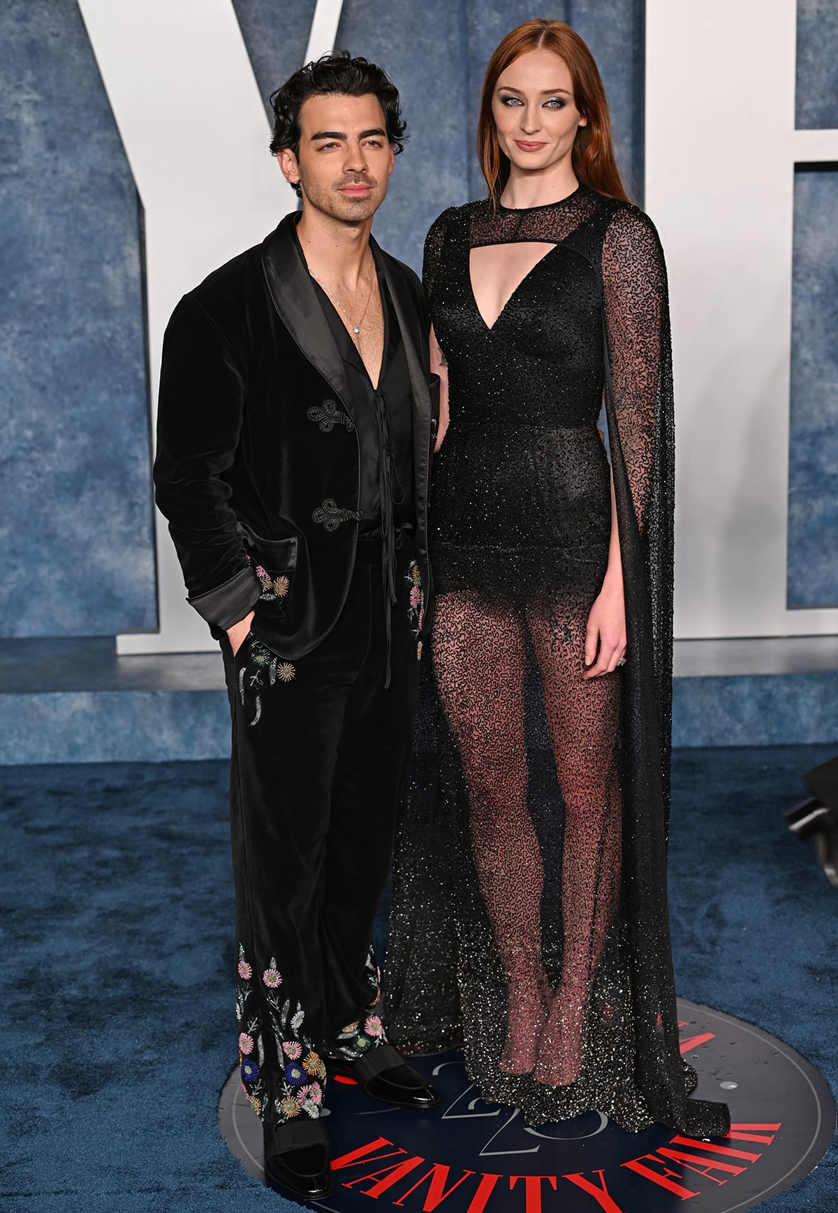 Joe Jonas and Sophie Turner attend the Vanity Fair Oscars after-party in coordinated black ensembles, with Turner in a sheer embellished gown and Jonas in a velvet suit with embroidered detailing