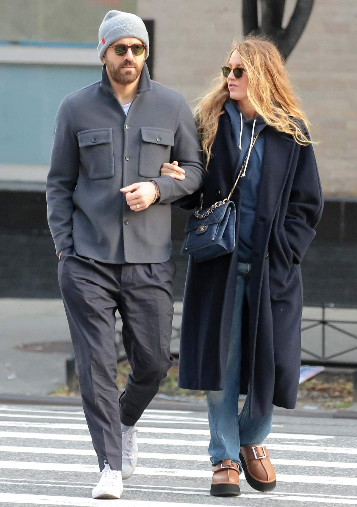 Ryan Reynolds looks dapper in a gray jacket with a white tee, charcoal gray pants, and a gray beanie