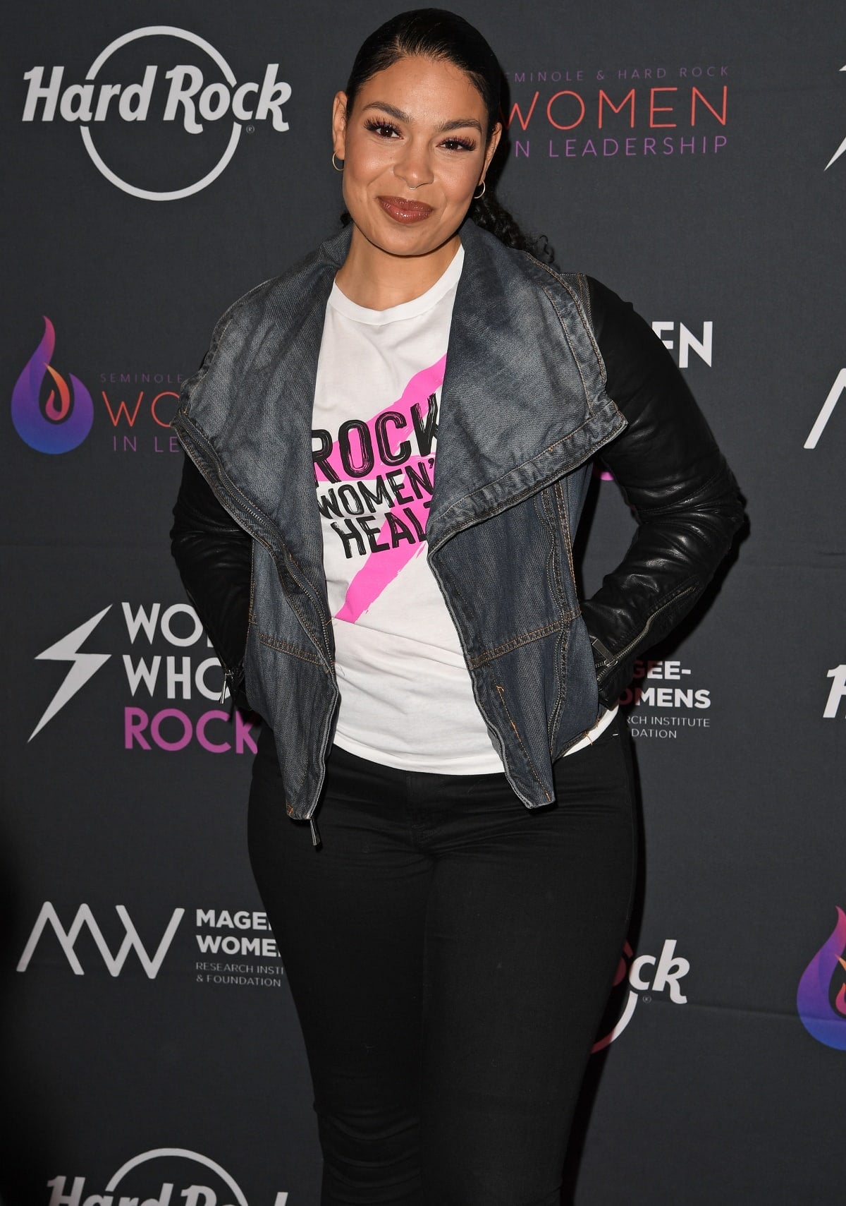 Jordin Sparks keeps it casual-chic in a graphic tee, black skinny jeans, and a denim-accented moto jacket at the Women Who Rock event