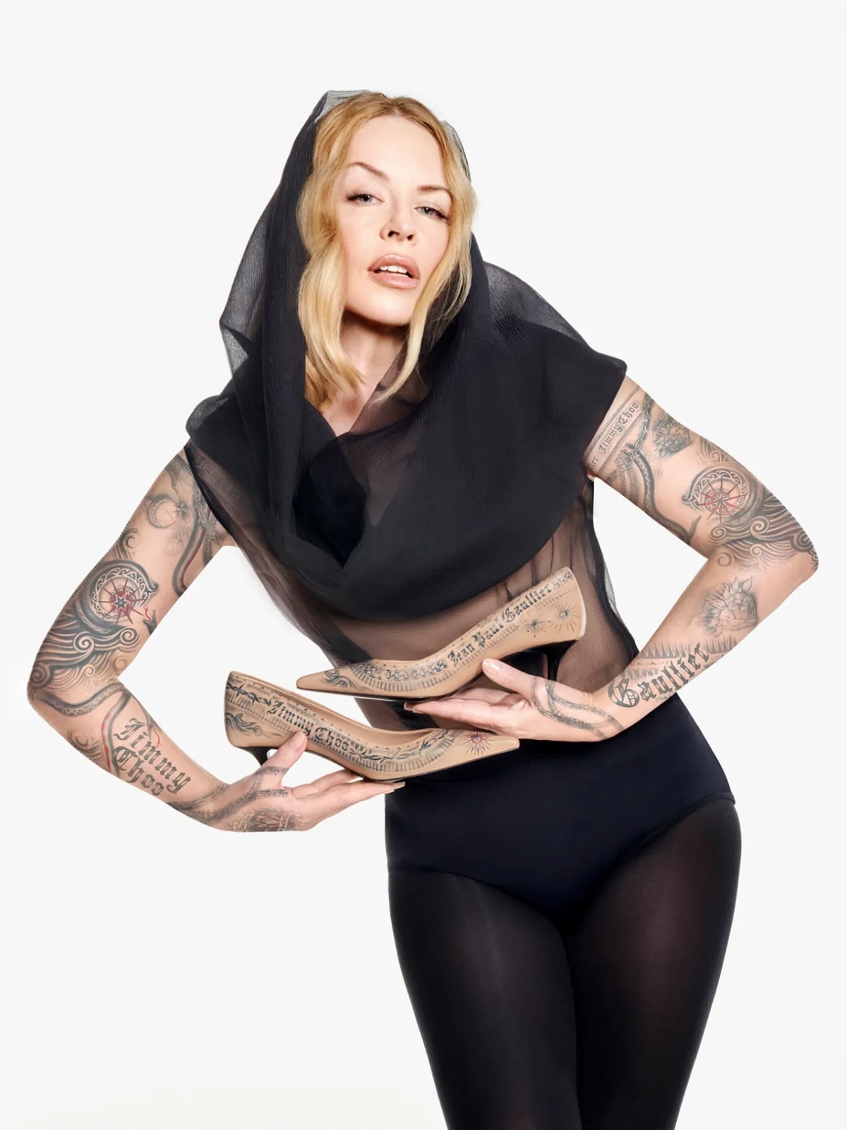 Kylie Minogue channels edgy elegance in sheer black and tattooed pumps from the Jimmy Choo x Jean Paul Gaultier collection, celebrating rebellious couture flair